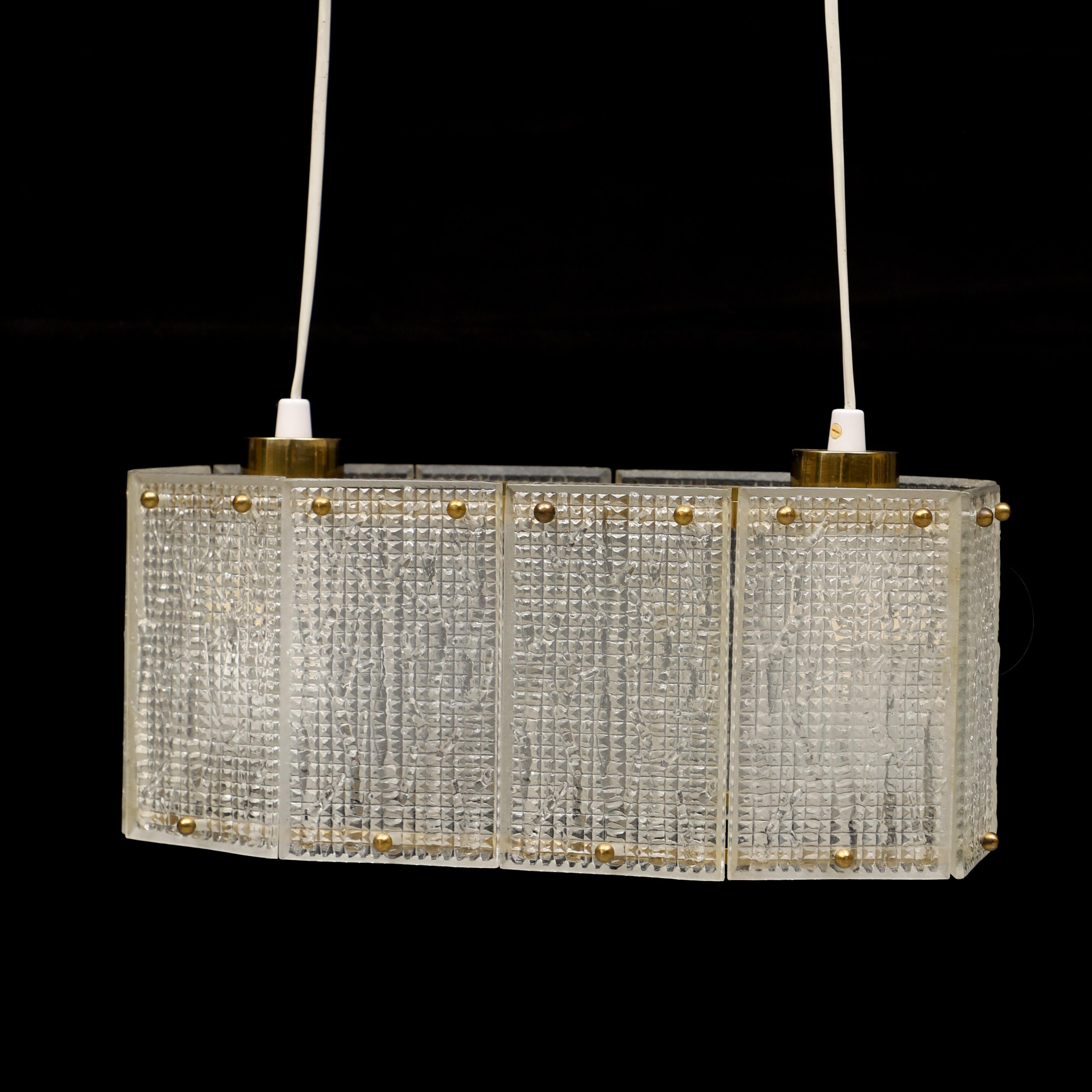 Deckenleuchte aus geformtem Glas und Messing von Orrefors Schweden 1960
Messingrahmen mit rechteckigen Glasplatten mit Reliefdekor. Länge 41, Breite 22, Höhe
20 cm.