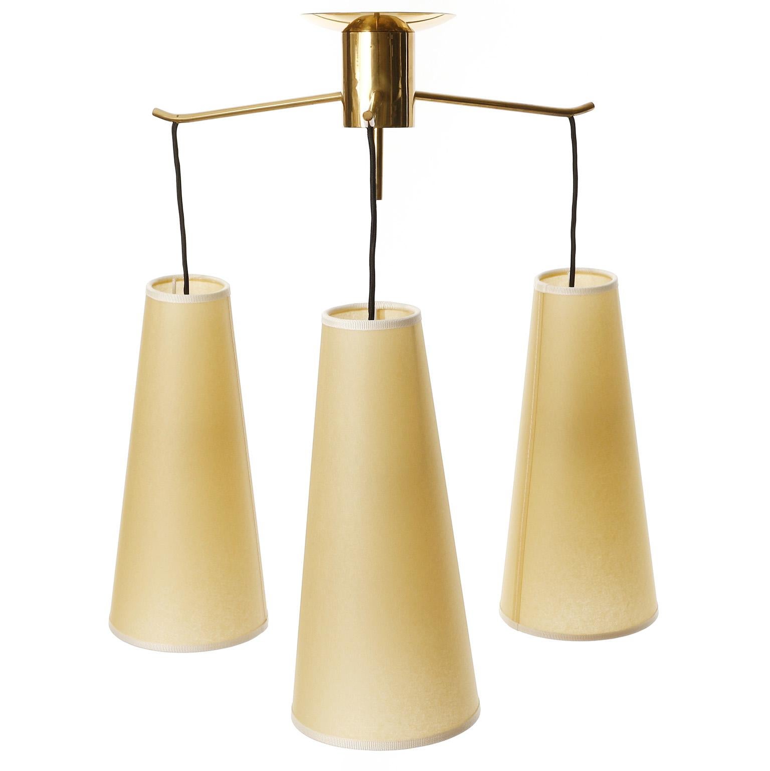 A ceiling light model 'POLKA' no. '5180/3' by J.T. Kalmar, Vienna, Austria, manufactured in midcentury, ca. 1960 (late 1950s or early 1960s).
Parchment lampshades hang from a star-shaped construction with three arms.
The light is great condition and