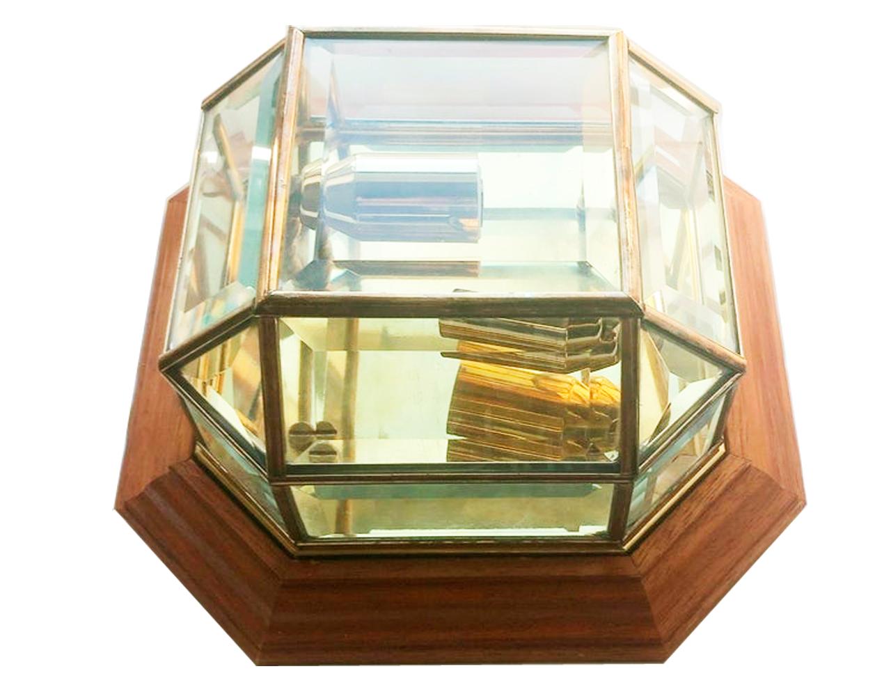 Beautiful brass, glass and wood wall light

  Wall light in the shape of a glass urn with a brass background and profiles that reflect the light. All surrounded by a light honey-colored wooden frame.
Each wall light has 2 narrow-cap bulbs.

 25x 25
