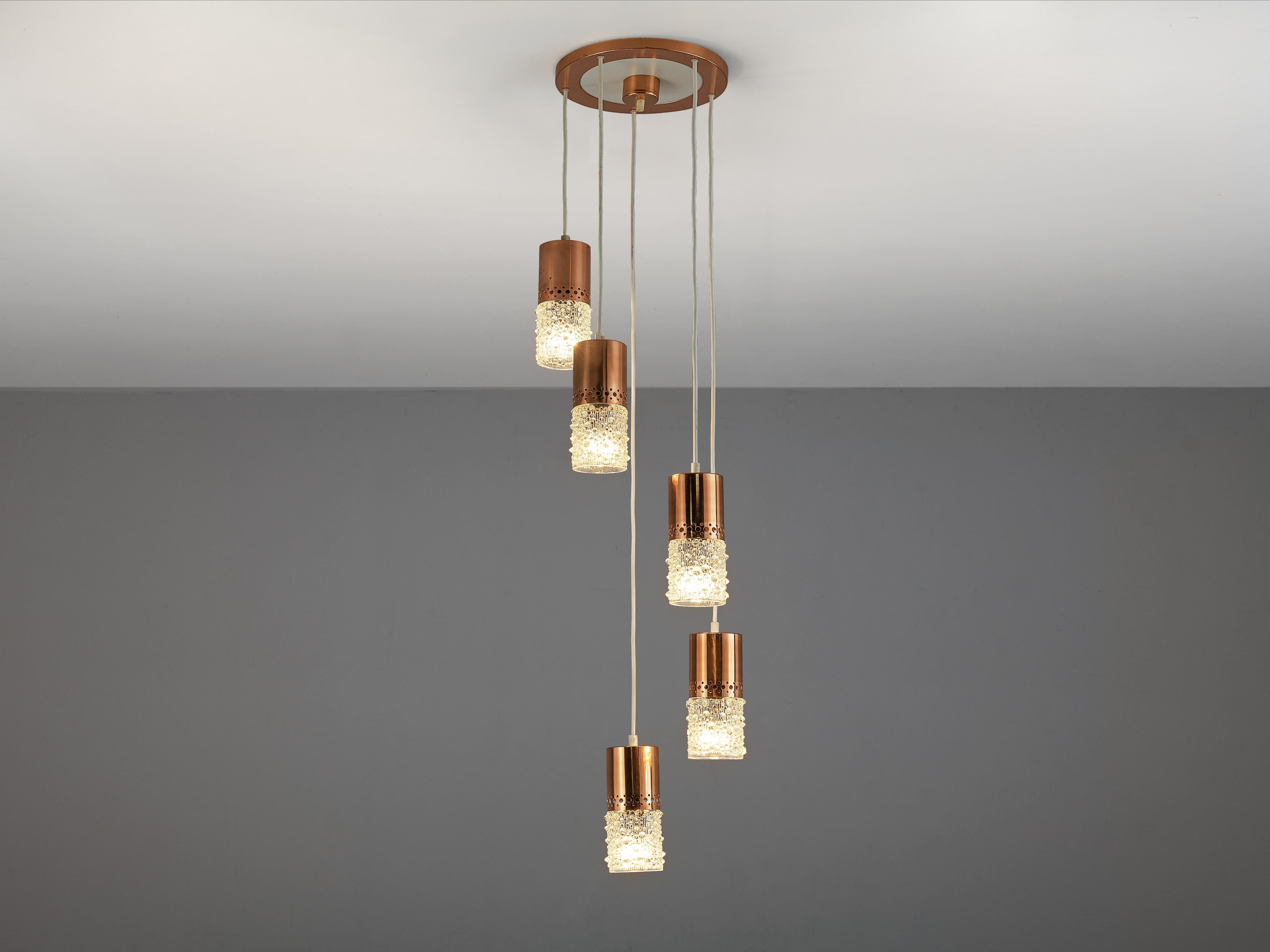 Ceiling light, glass, copper, Europe, 1970s

Wonderful ceiling light with five pendants. All lights feature a cylindrical copper base with a with a handblown glass shades. The structured glass, reminiscent of the style of Tapio Wirkkala, of the