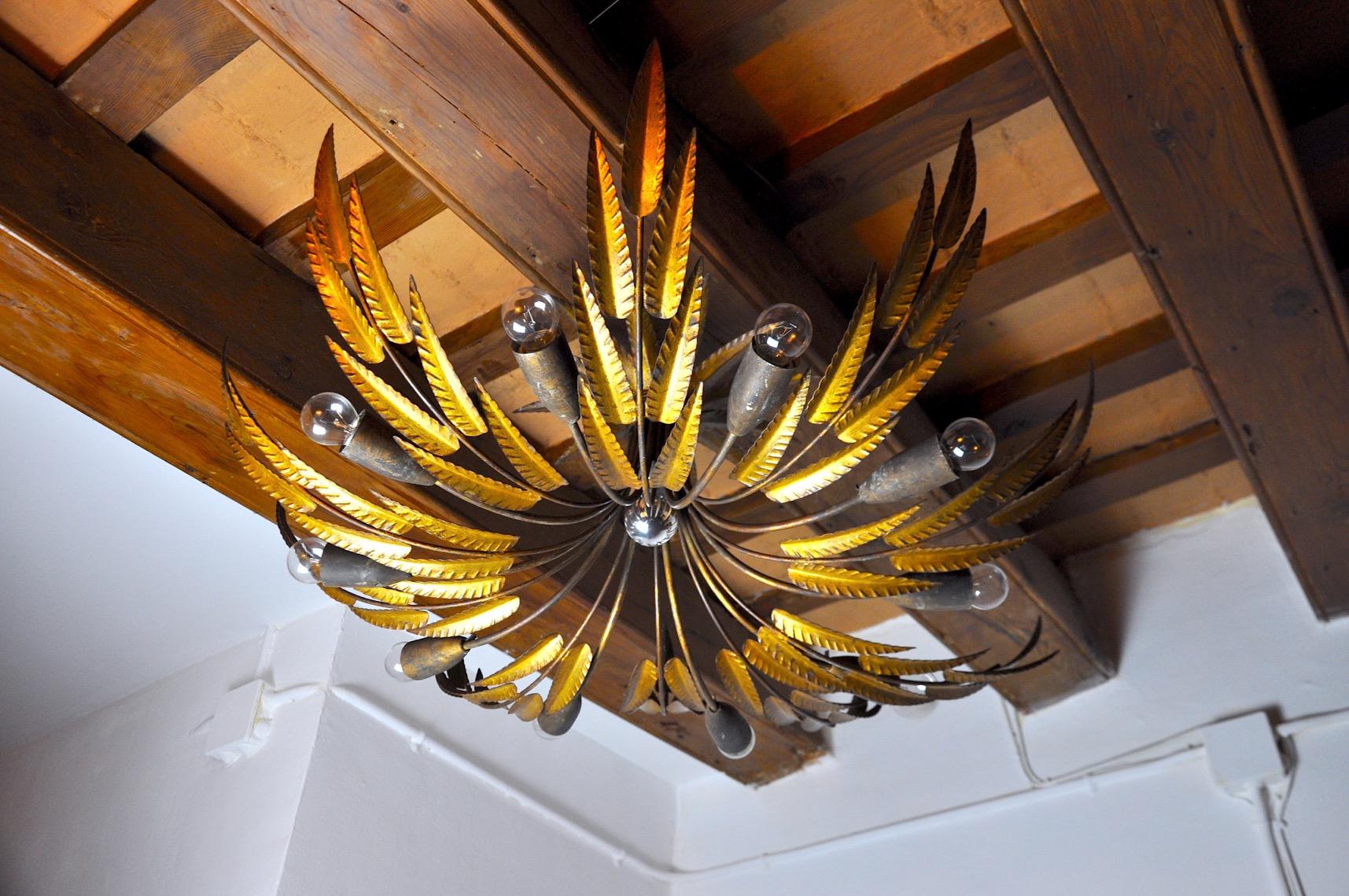 Rare and very large ferroarte chandelier designed and produced in Spain in the 1960s. Sun-shaped structure representing leaves. Unique wrought iron work finished with gold leaf. The ceiling light is made up of 11 lights. Rare design object that will