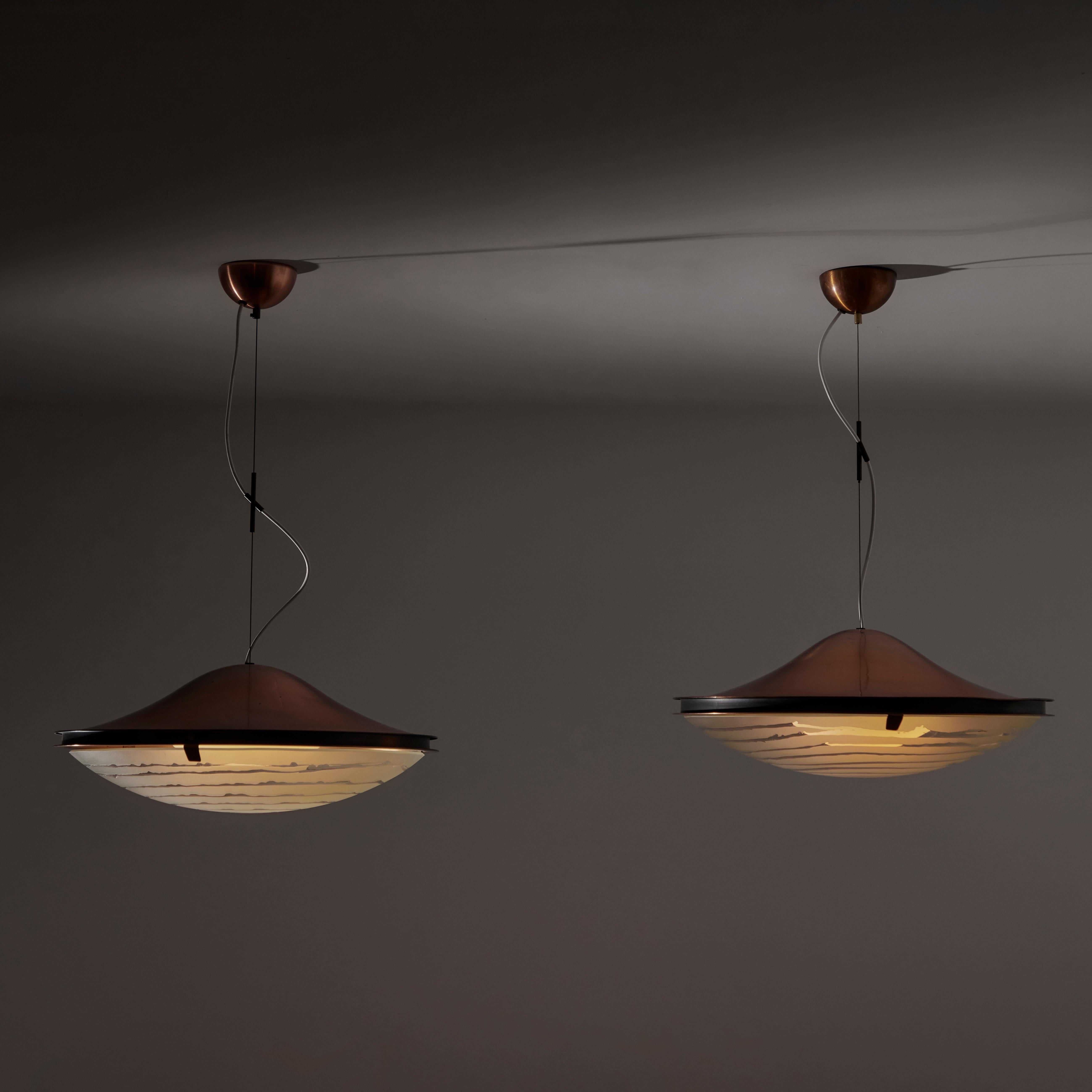Ceiling lights by Gaetano Sciolari for Stilnovo. Designed and manufactured in Italy, circa 1950. Aluminum frame with anodized copper finish, featuring a unique etched spiral within the frosted glass shade that encloses an opaline white diffuser