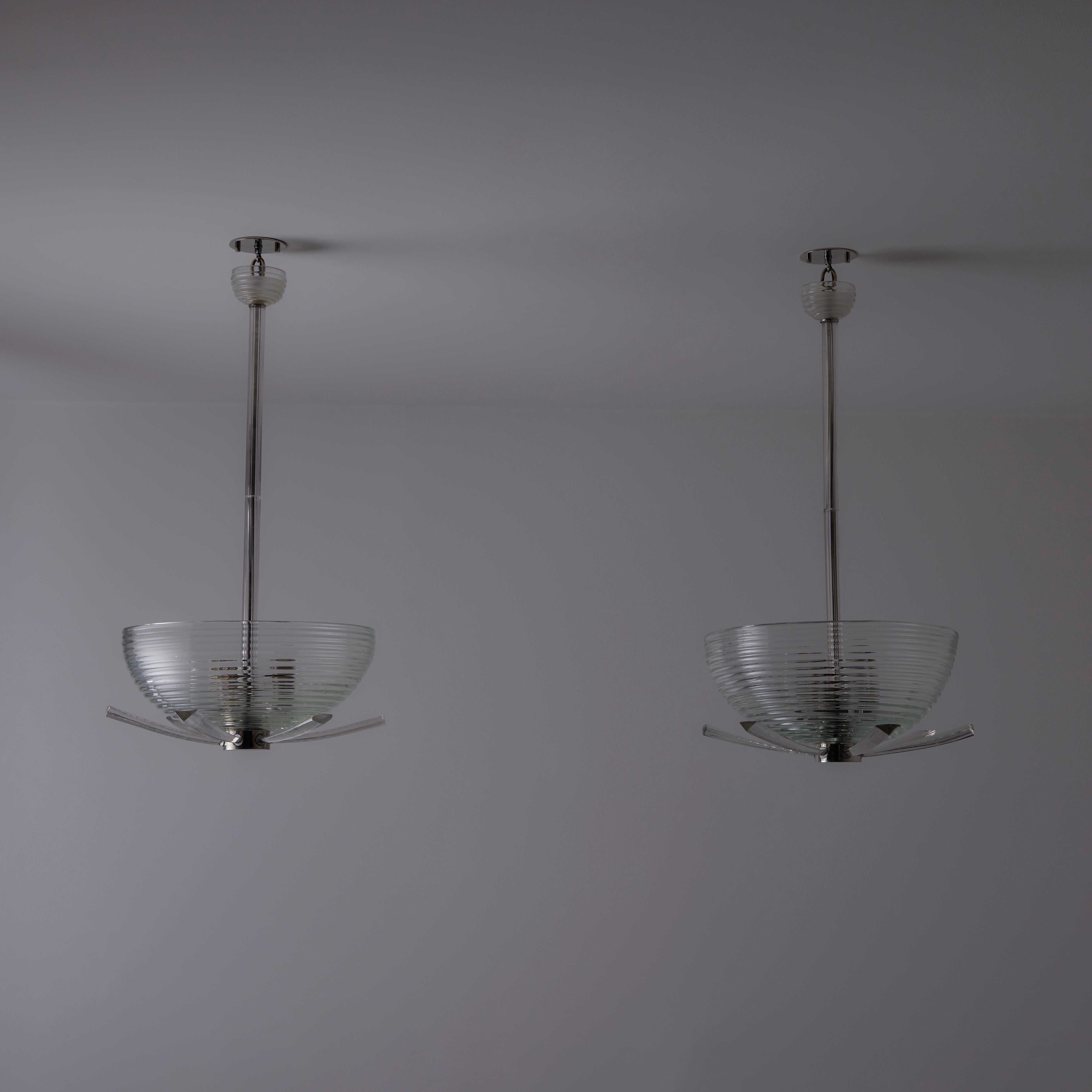 Ceiling Lights by Seguso. Designed and manufactured in Italy, circa the 1940s. All glass pendants with Murano glass blown bowls, glass ribbed stem and glass arms for an added detail on the bottom relief. Each pendant holds a tri-socket consisting of