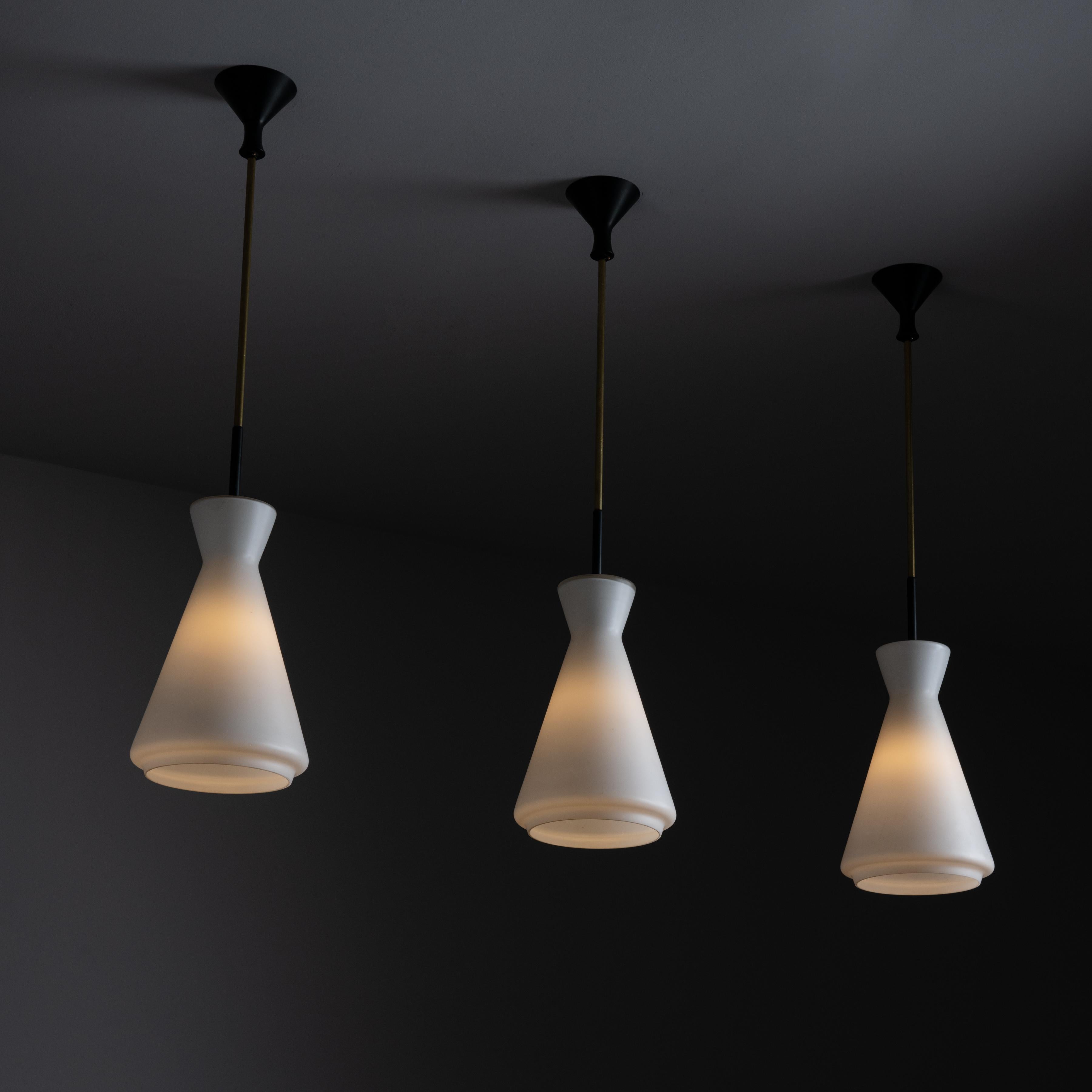 Ceiling lights by Stilnovo. Designed and manufactured in Italy circa the 1960s. Structural pillar like pendant consisting of opal glass on a minimal enameled black and brass stem. Holds one E27 socket type, adapted for the US. We recommend one 60w