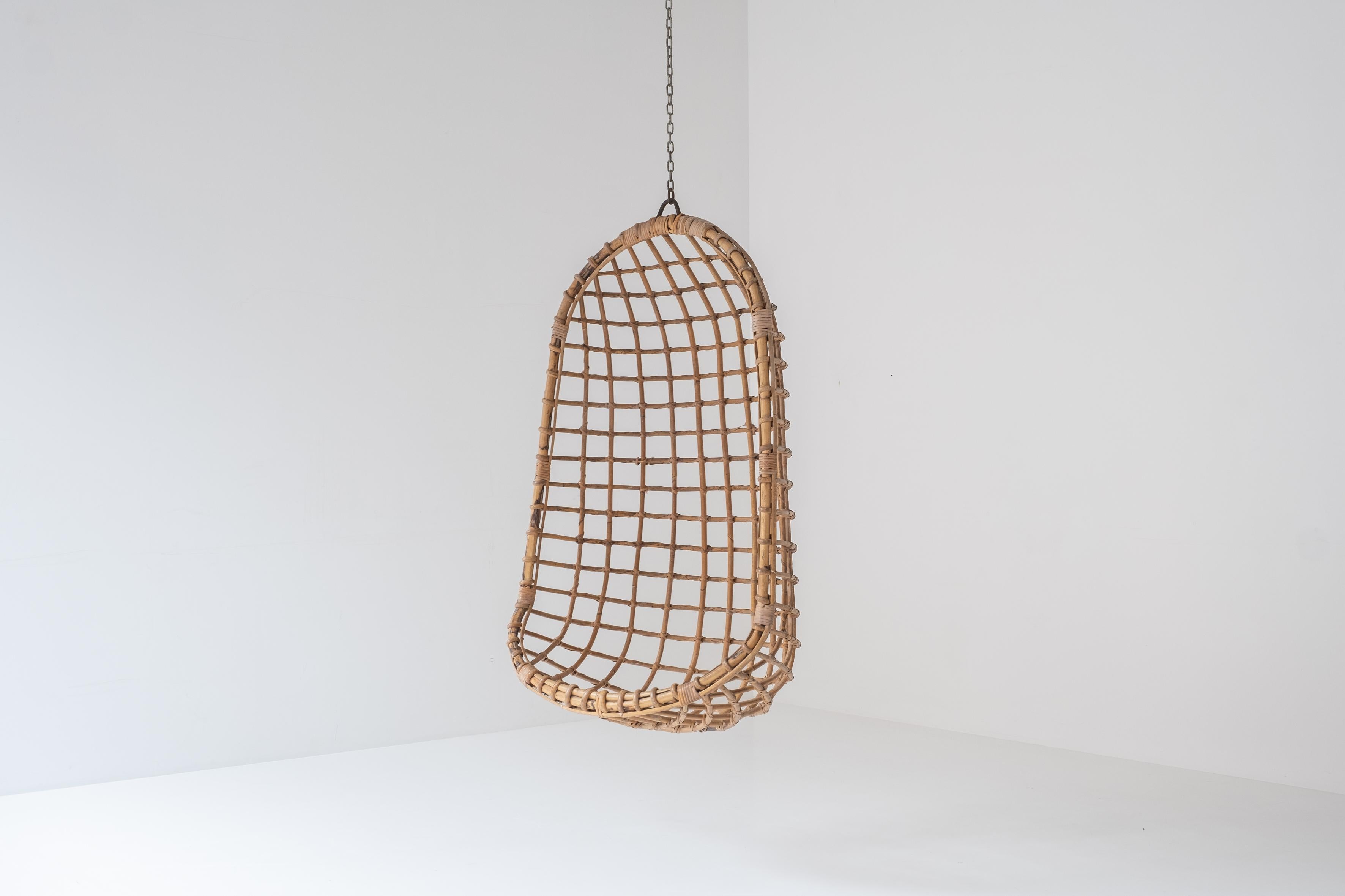 Ceiling mounted Egg chair by Rohé Noordwolde, The Netherlands 1960’s. This lounge chair is made out of bent bamboo and cane. It is presented in its original condition and remains the original iron cage hanging suspension.