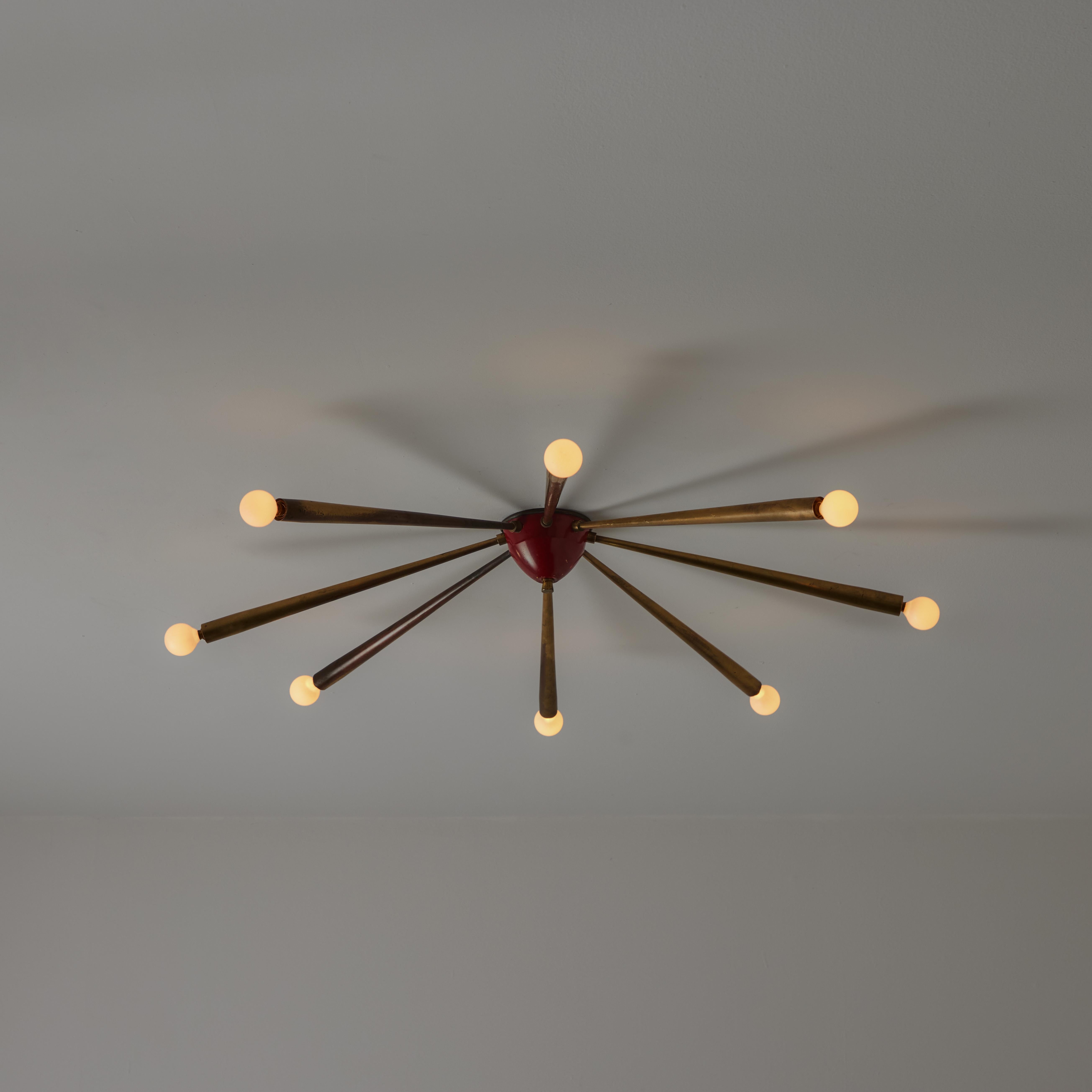 Ceiling or Wall Light Attributed to Oscar Torlasco. Designed and manufactured in Italy circa the 1950s. A total of eight tapered brass armatures sprayed from a centered nucleus. The center cup is finished in red. All finishes hold a gorgeous