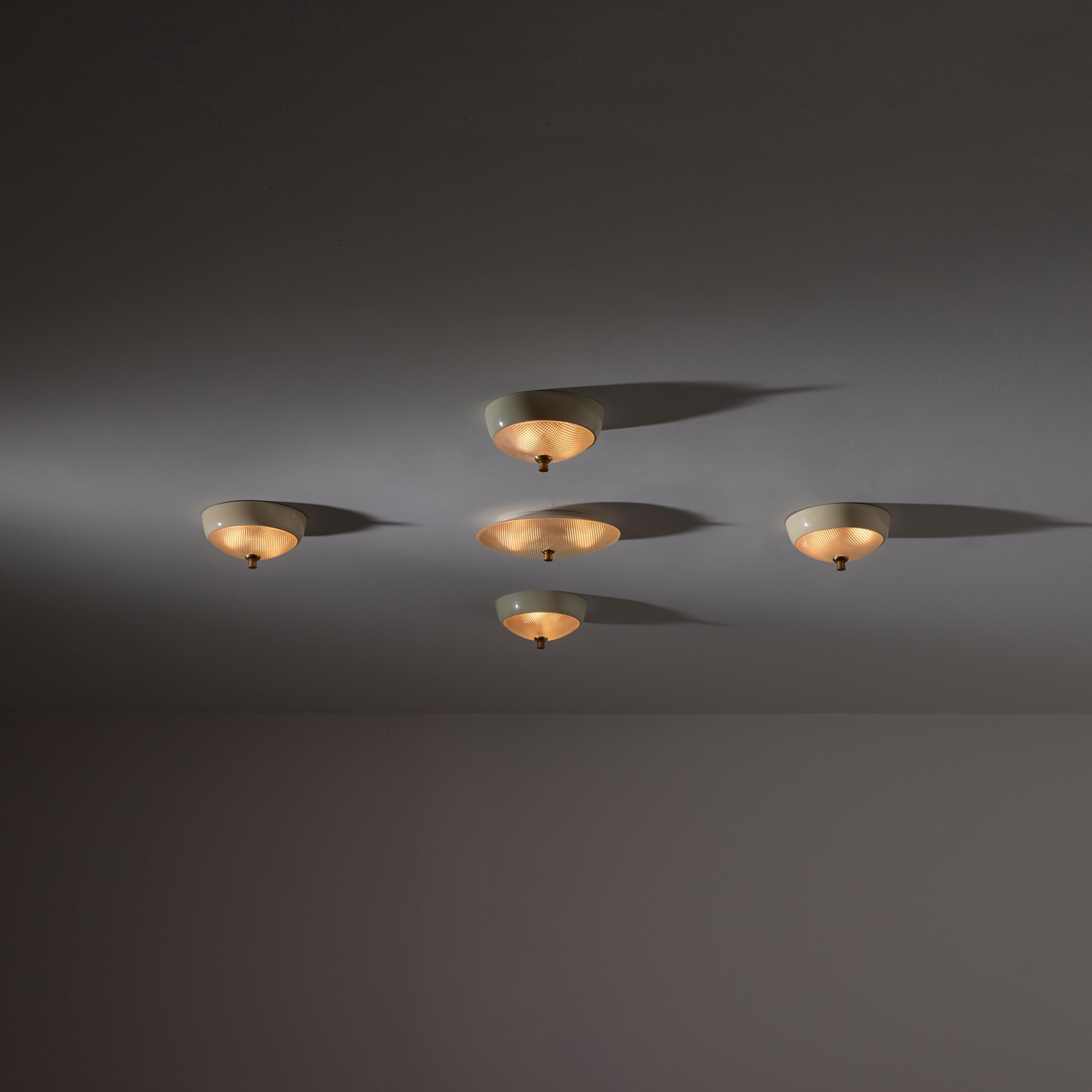 Ceiling or Wall Lights by Lumi. Designed and manufactured in Italy, circa the 1950s. These petite enameled flush mounts are a lot of five comprising of four circles (two pairs match with slightly variable colors, and one oval on its own). Each light