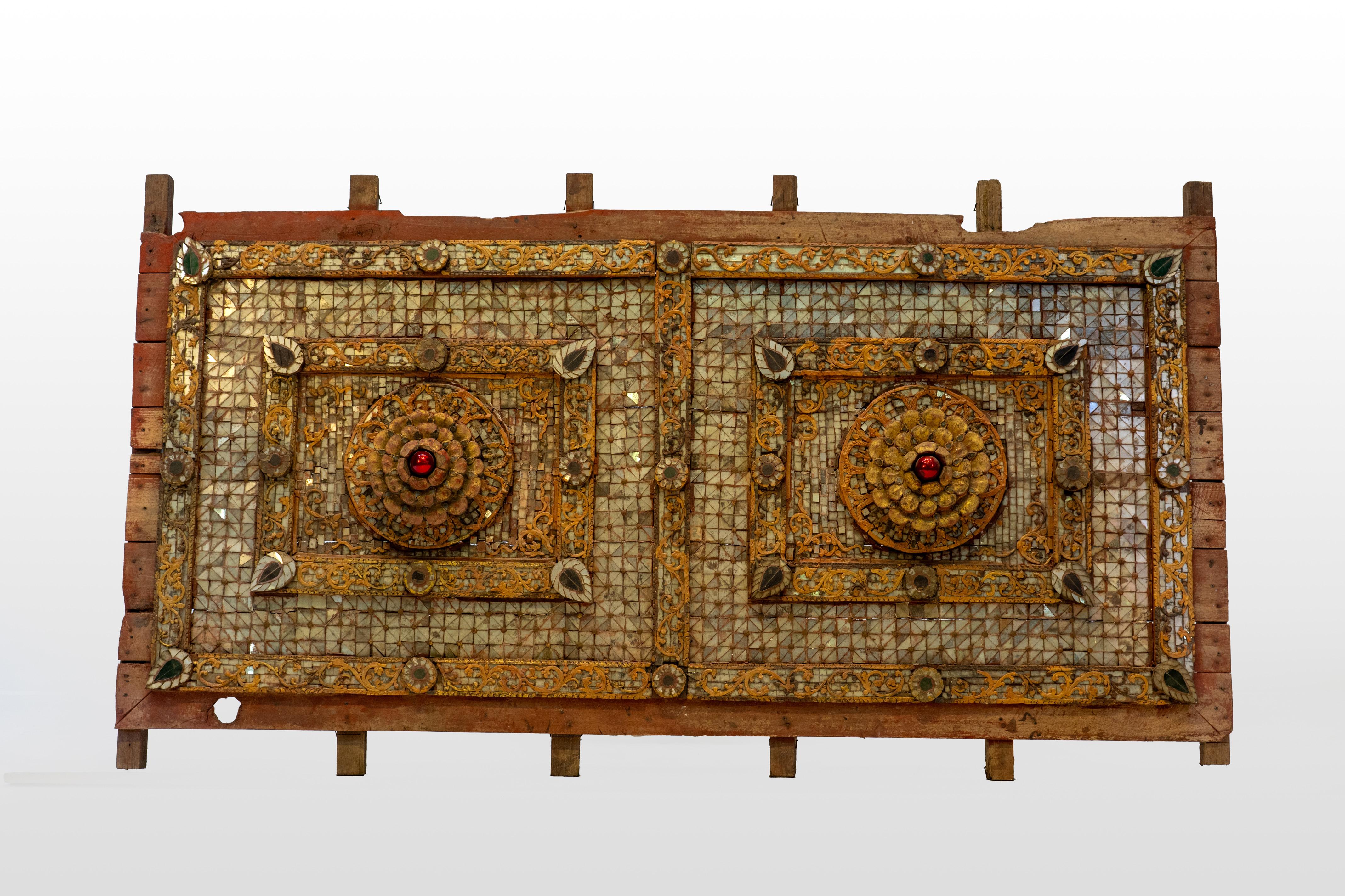 This original 1920's ornate temple ceiling panel from Chiang Mai, Thailand, exudes traditional craftsmanship and spiritual significance. Adorned with intricate mica and floral designs, this exceptional panel once graced the ceiling above a Buddha