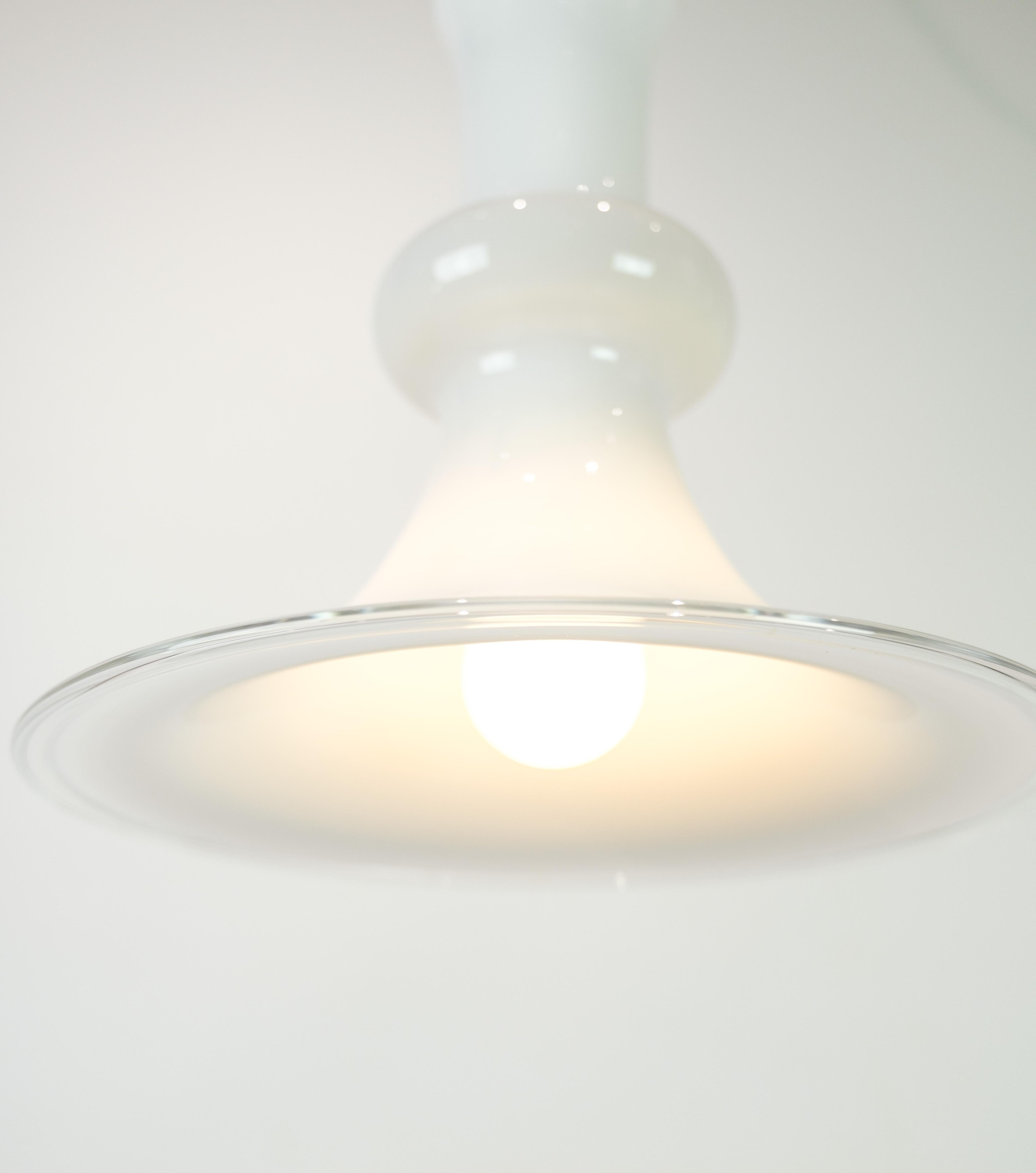 Pendant model Etude 1 is a beautiful example of Michael Bang's design from 1978. The pendant is made of clear and white opal glass and is manufactured by Holmegaard, one of Denmark's most renowned glass manufacturers.

The design of the pendant is