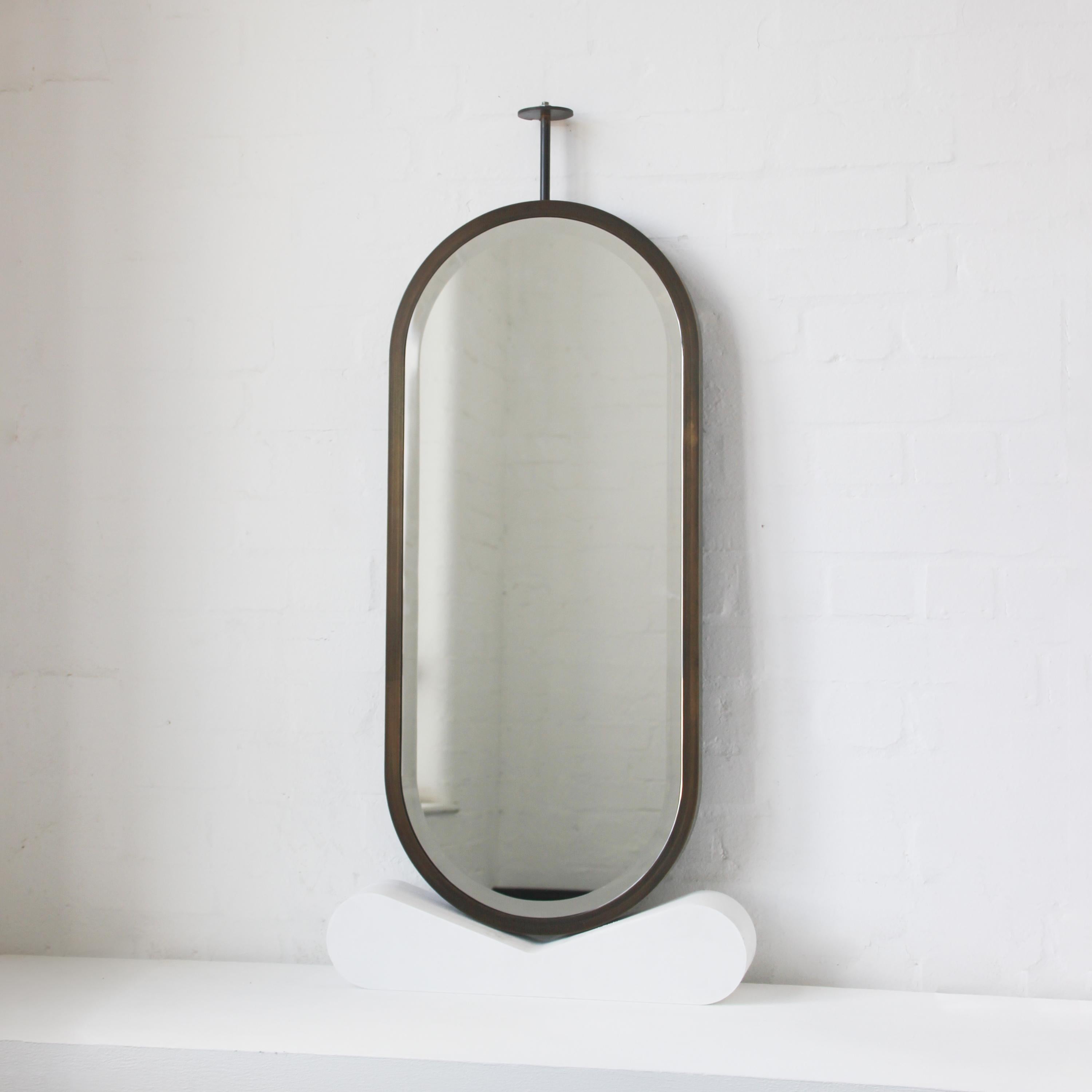 Contemporary ceiling suspended Capsula™ pill shaped mirror with a bevel and a handcrafted brushed brass full frame. Designed and handcrafted in London, UK.
This mirror is fully customisable.

Dimensions (customisable):
39cm W x 90cm H x 3cm D /