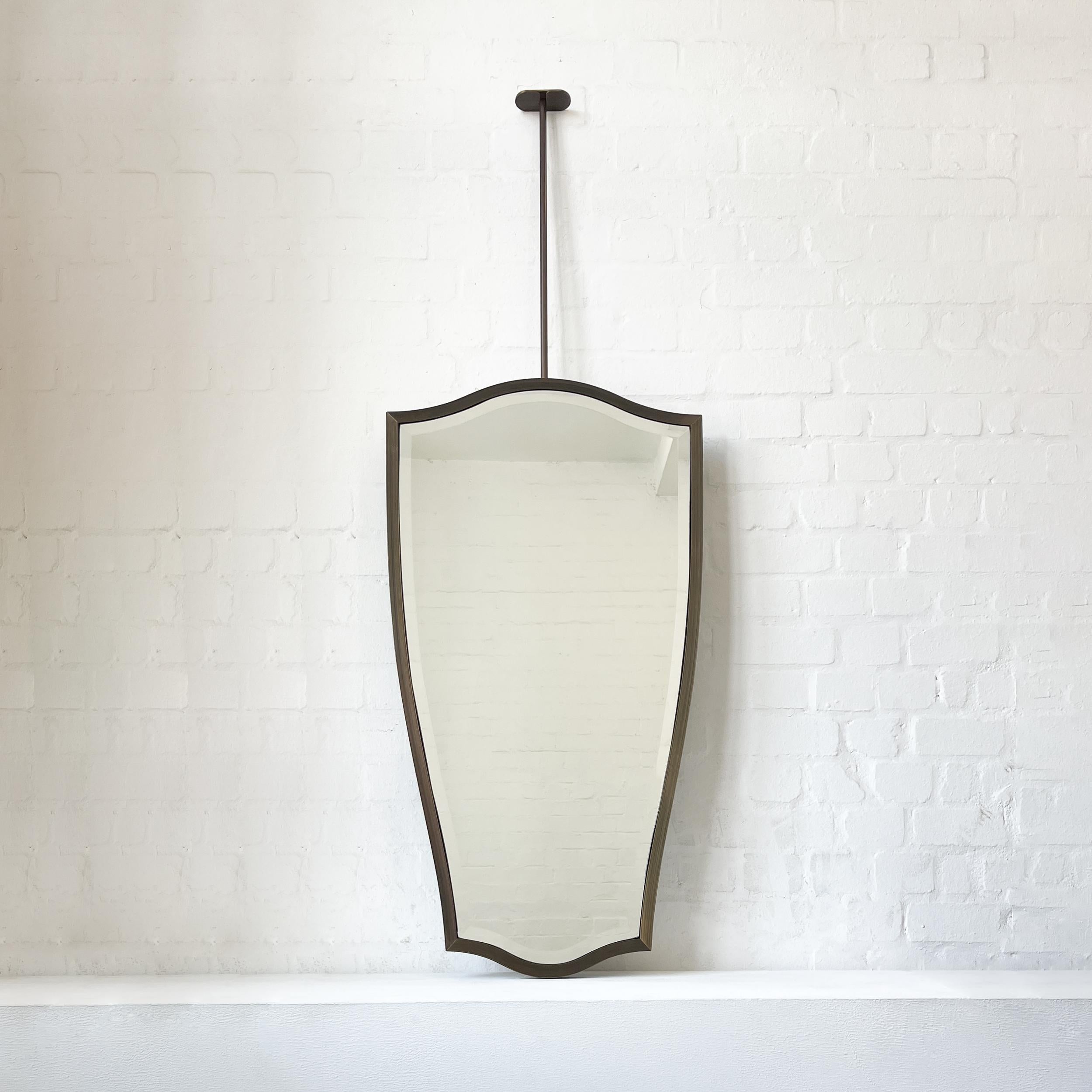 Squisito specchio a soffitto sospeso della serie N.7 con un elegante smusso e una cornice in ottone massiccio. Progettato e realizzato a mano a Londra, nel Regno Unito.

Disegnato da JL Alguacil, questo specchio è una sofisticata fusione di