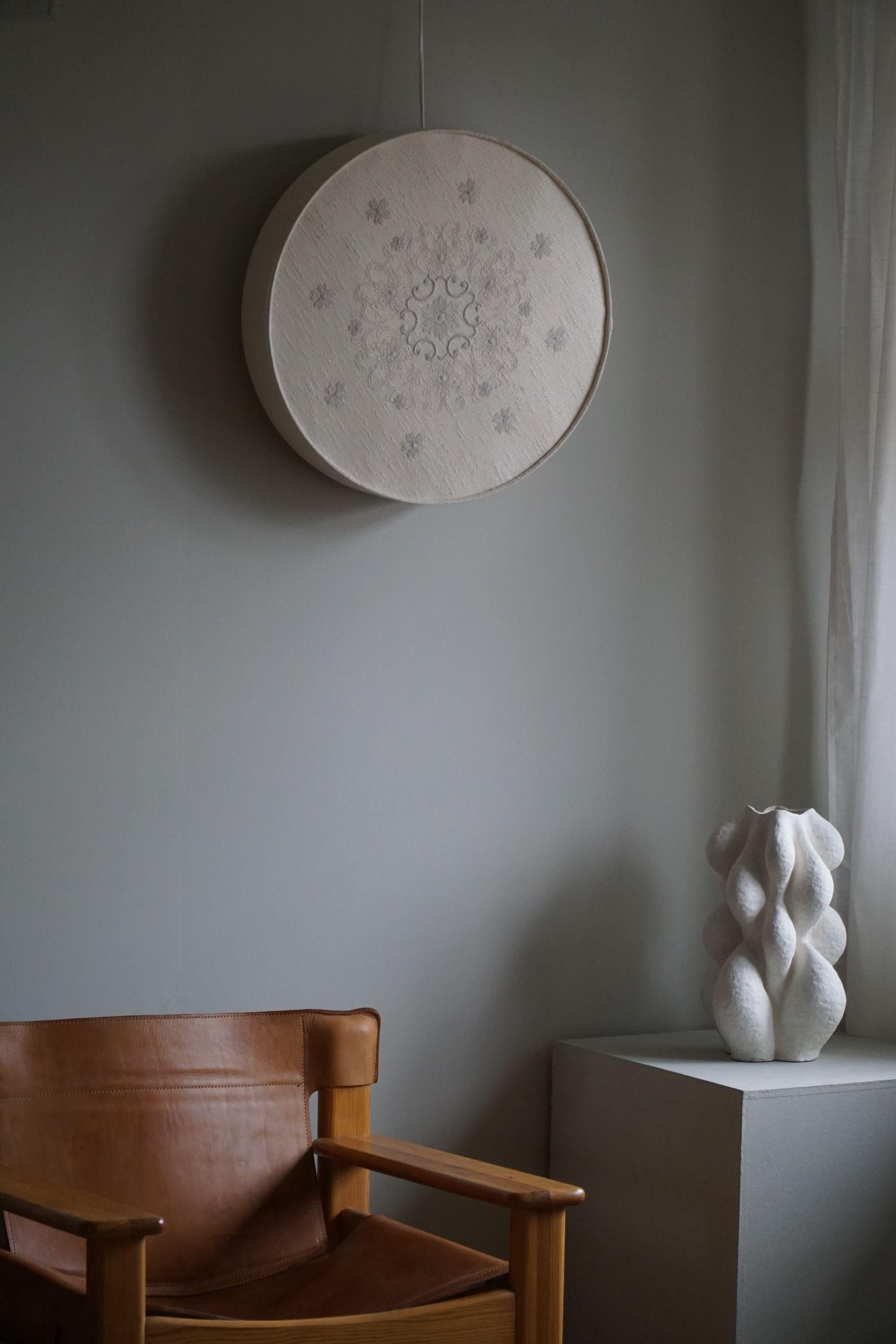 Une belle applique ronde pour plafond/mur en lin et soie. Fabriqué en Suède dans les années 1960, avec un grand sens de l'élégance et de la simplicité caractéristiques de l'ère suédoise du milieu du siècle. Le luminaire présente une forme circulaire