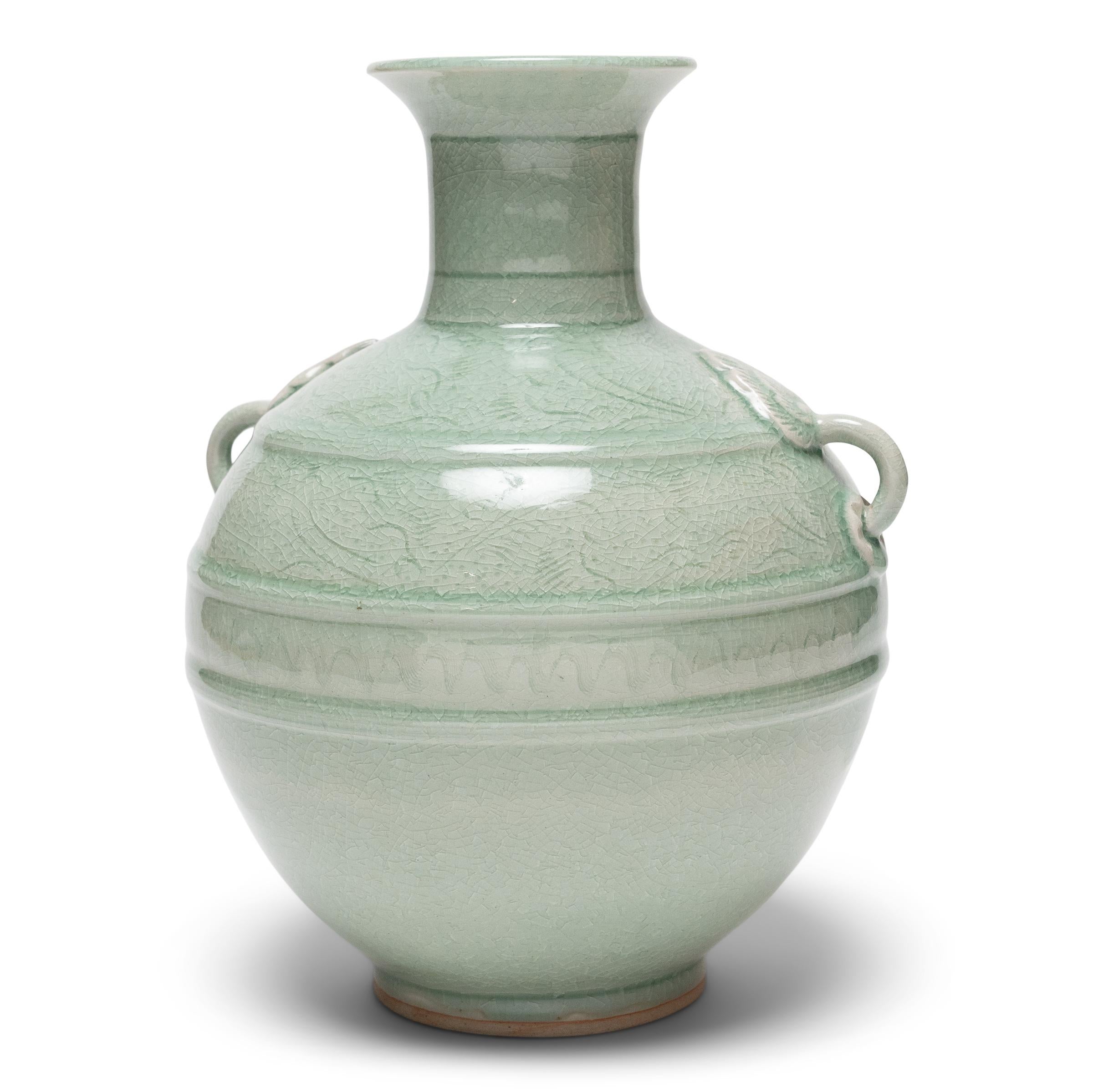 Described in ancient Chinese texts as the “moon dyed with spring water,” celadon ceramics are prized for their well-proportioned forms and luminous blue-green glazes. This vintage celadon vase was sculpted by artisans of the Mengrai Kilns in