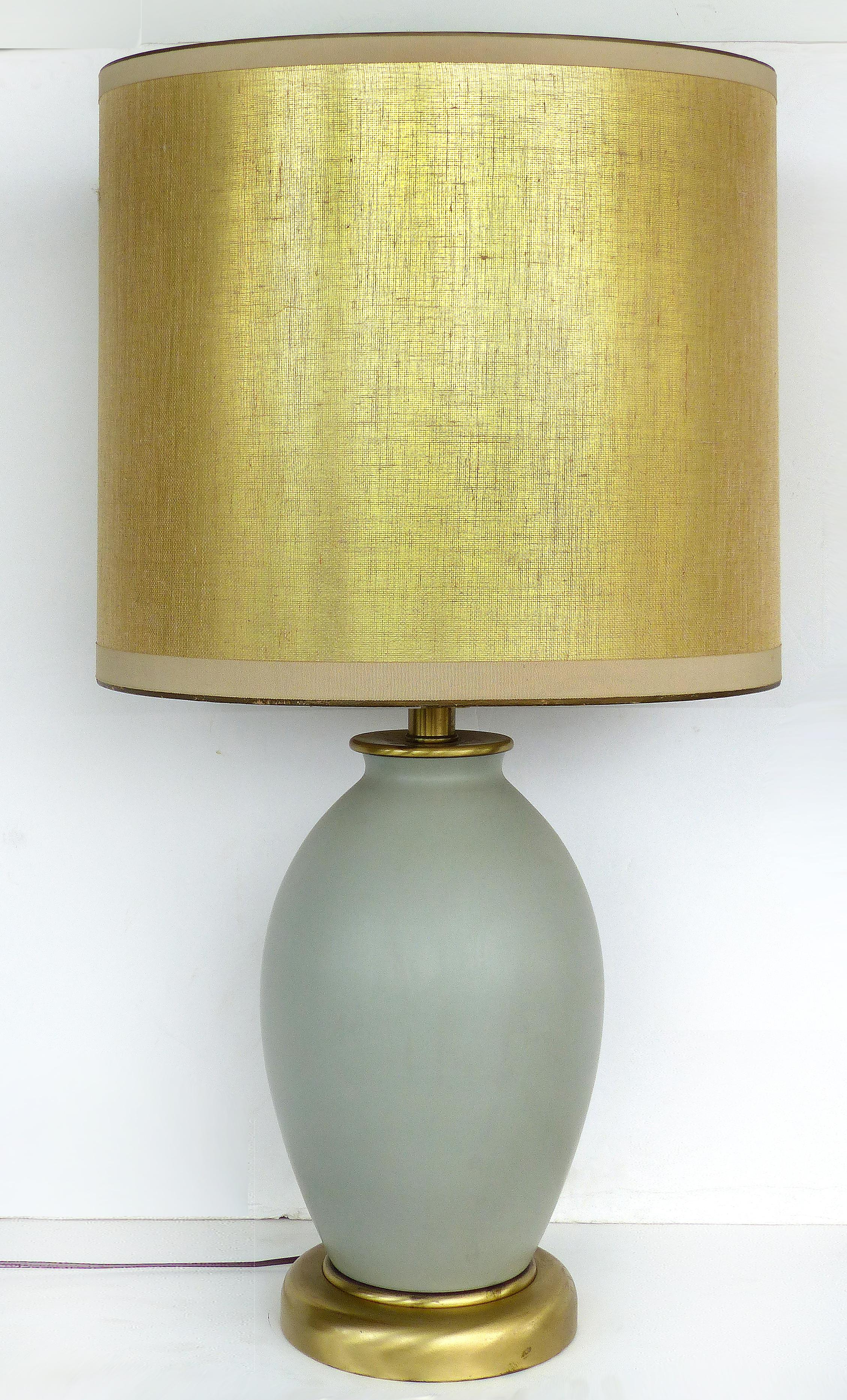 Celadon ceramic lamps with shades and brass bases

Offered for sale is a pair of celadon green ceramic lamps on brass bases with custom shades. These lamps have single sockets which accommodate standard bulbs. One of the shades has a small area of