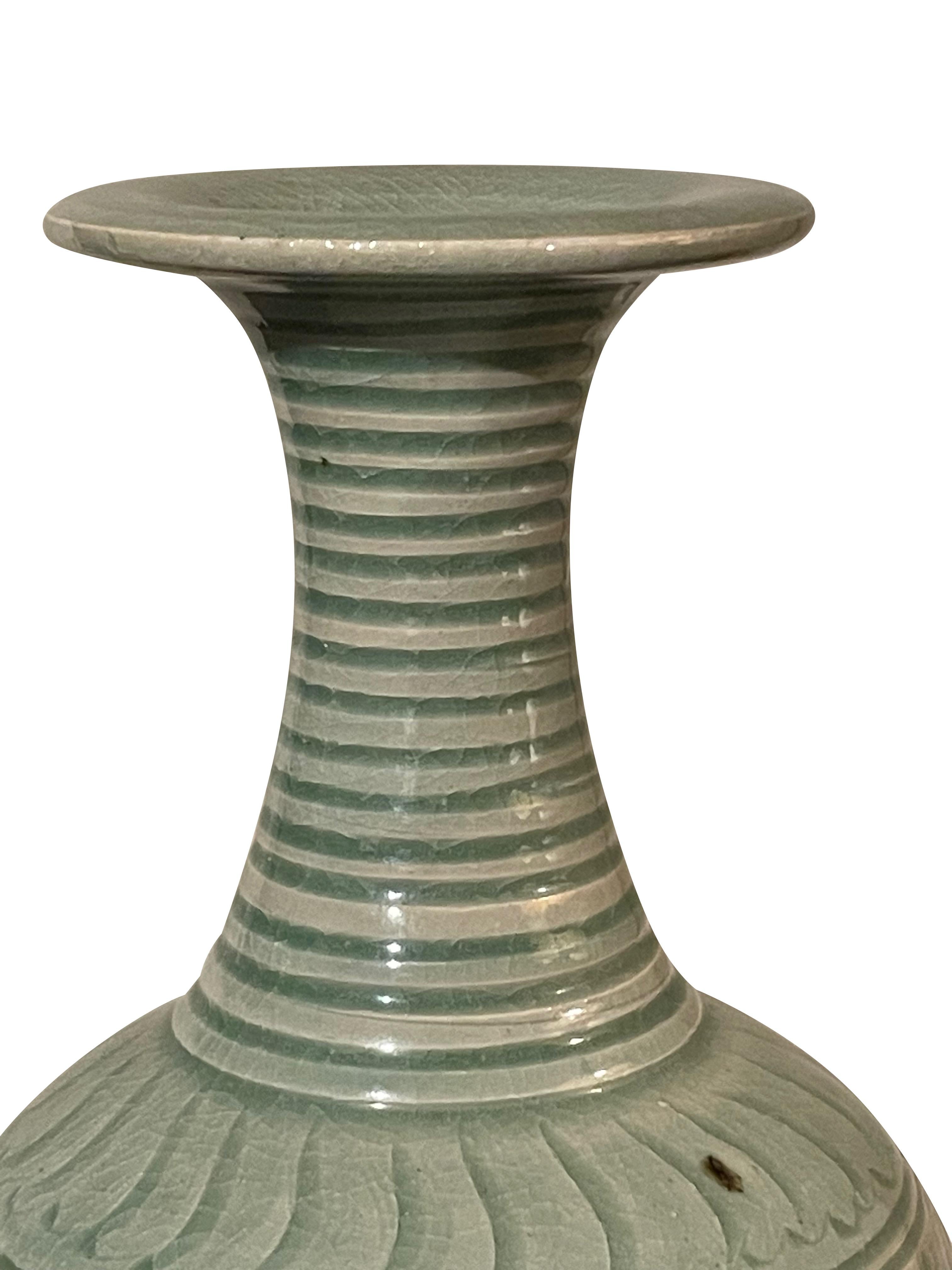 Contemporary Chinese celadon glazed vase with decorative pattern at base.
Horizontal raised rib detailing at neck.
