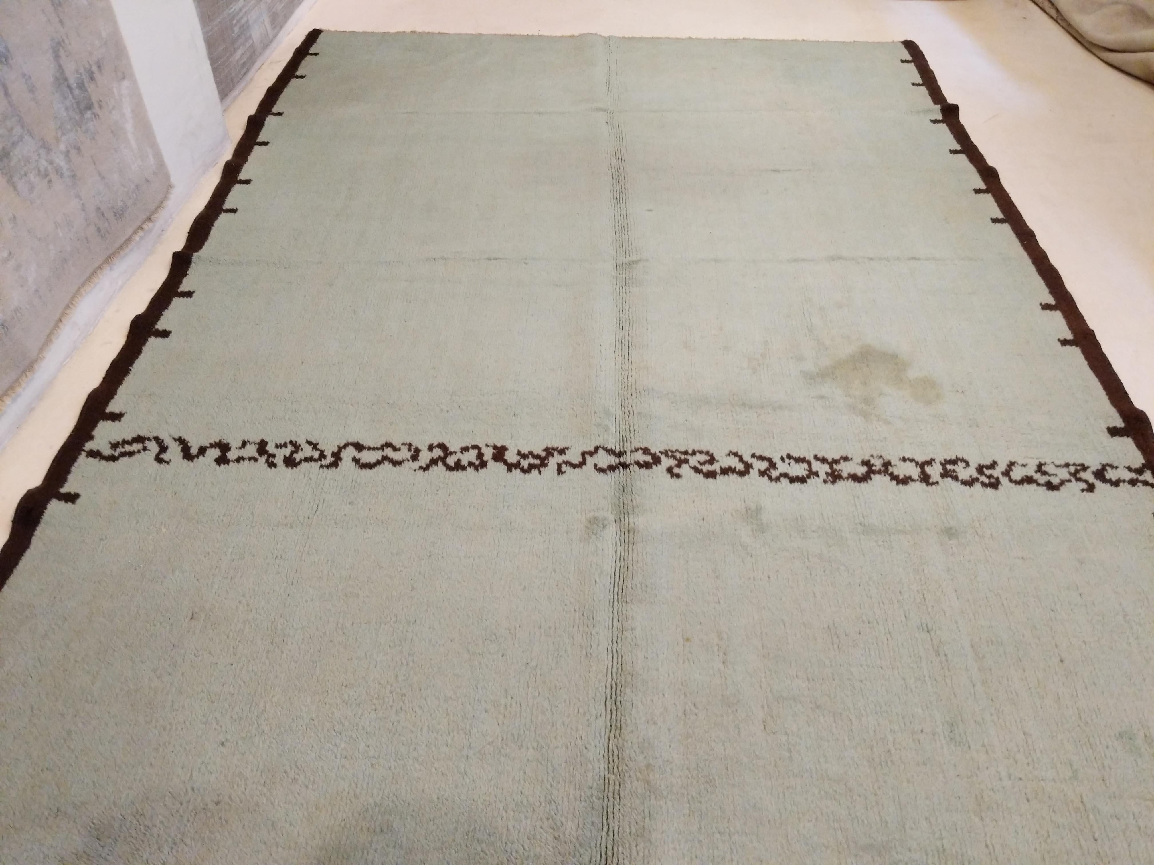 Ein eleganter französischer Art-Déco-Teppich, der sich durch einen ungewöhnlichen keladongrünen Hintergrund auszeichnet, der auf etwa drei Vierteln seiner Länge durch ein horizontales Motiv in Schokoladenbraun unterbrochen wird. Letztere Farbe ziert