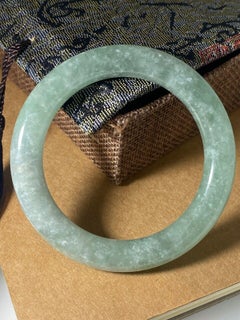 Celadon Grüner Mottled Jade-Armreif. Gewicht: 58,7 g. Umfang: 21 cm.