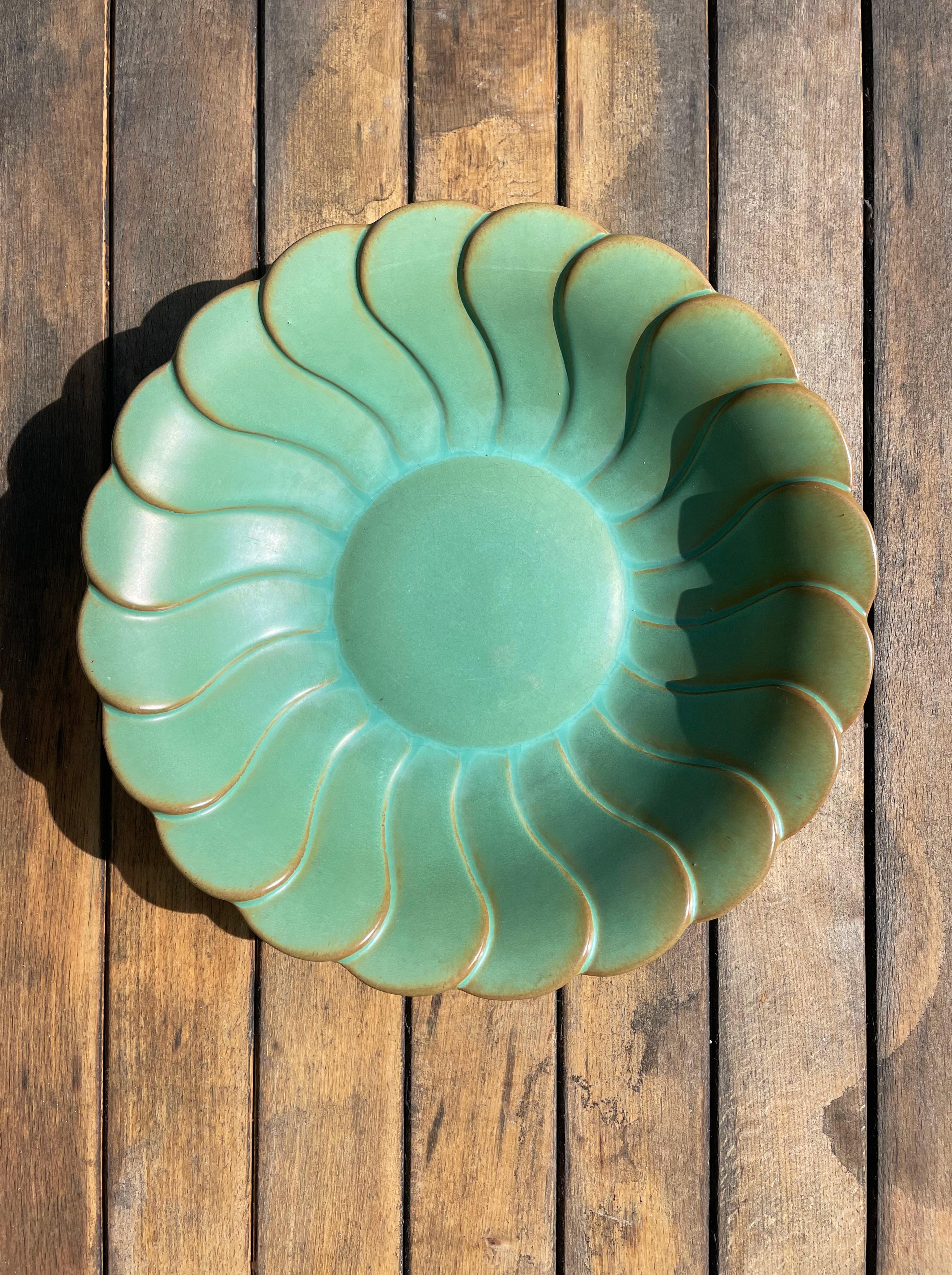 Dusty olive celadon green art deco faience sun-like bowl plate centerpiece by artist and designer Arthur Percy (1886-1976, student of Henri Matisse) for the Gefle porcelain factory in the 1930s. Organic fan shapes accentuated by golden bronze