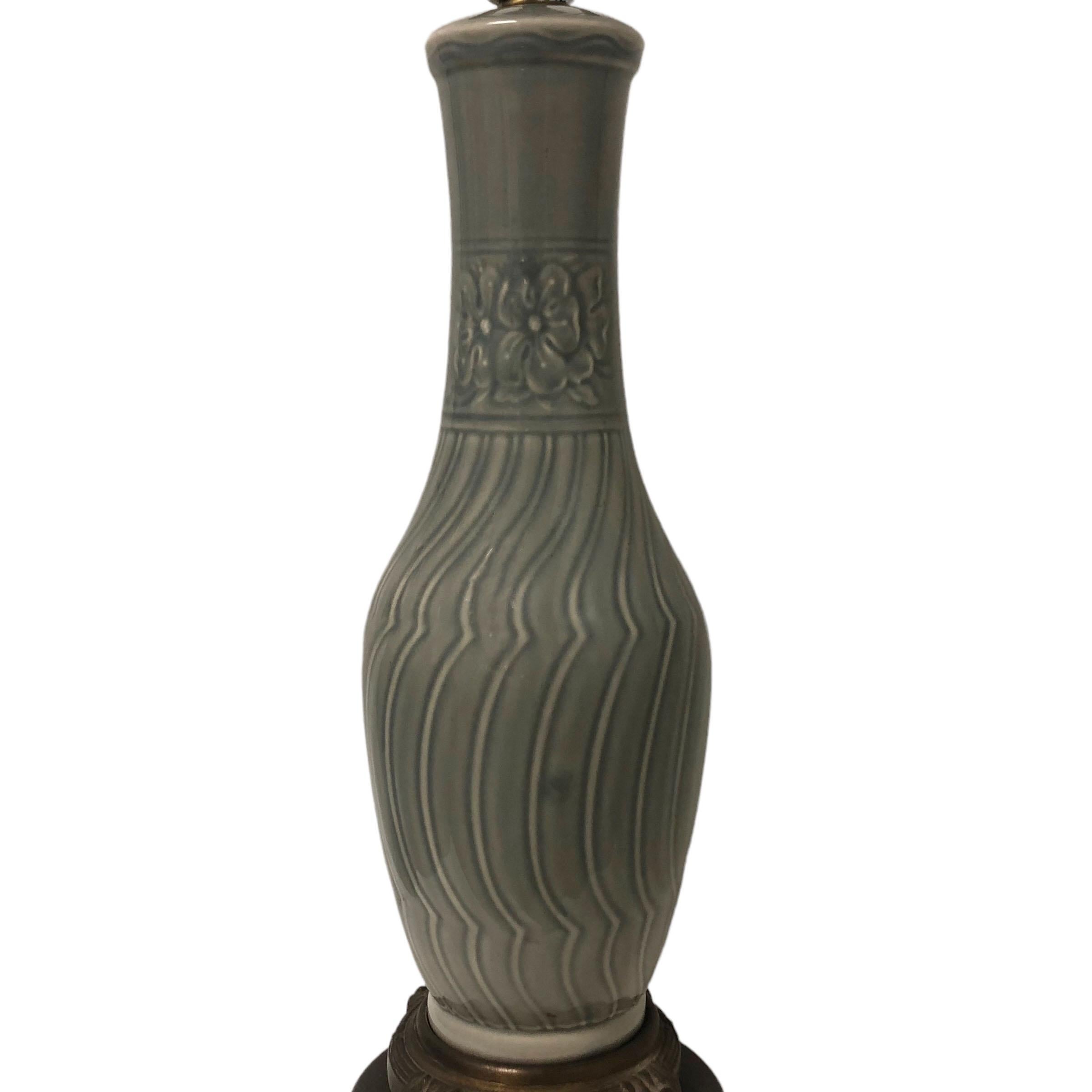 A celadon color lamp in the Chinese taste and form. The base is staggered bronze in the French taste. It is a very nice porcelain lamp in good working condition for the age and does have a finial. American from the 1920s.