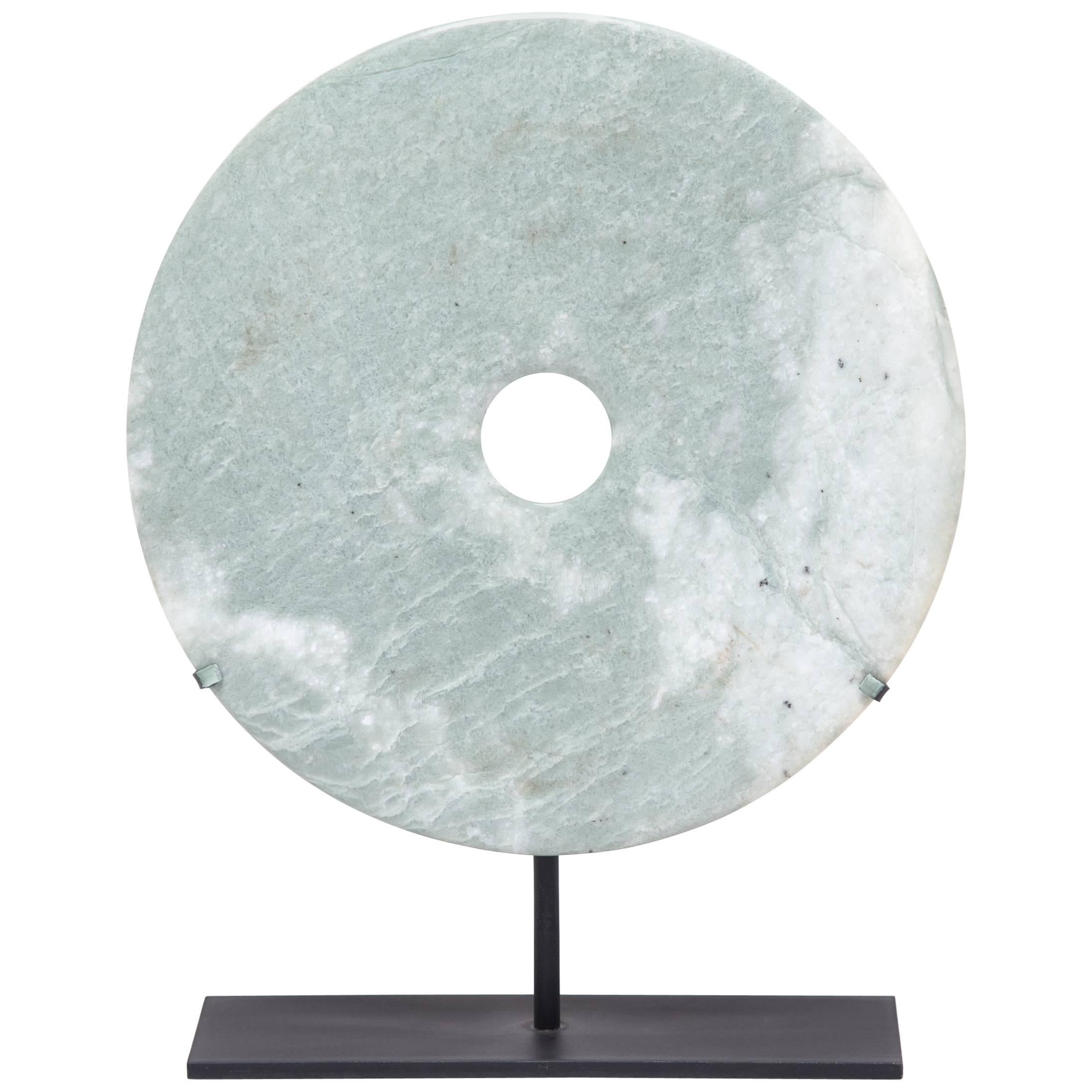 Found in the tombs of ancient Chinese emperors and aristocrats, bi discs such as this have a mysterious and spiritual history, and their function and significance remain uncertain. Thought to provide a conduit to the heavenly realm, bi discs are