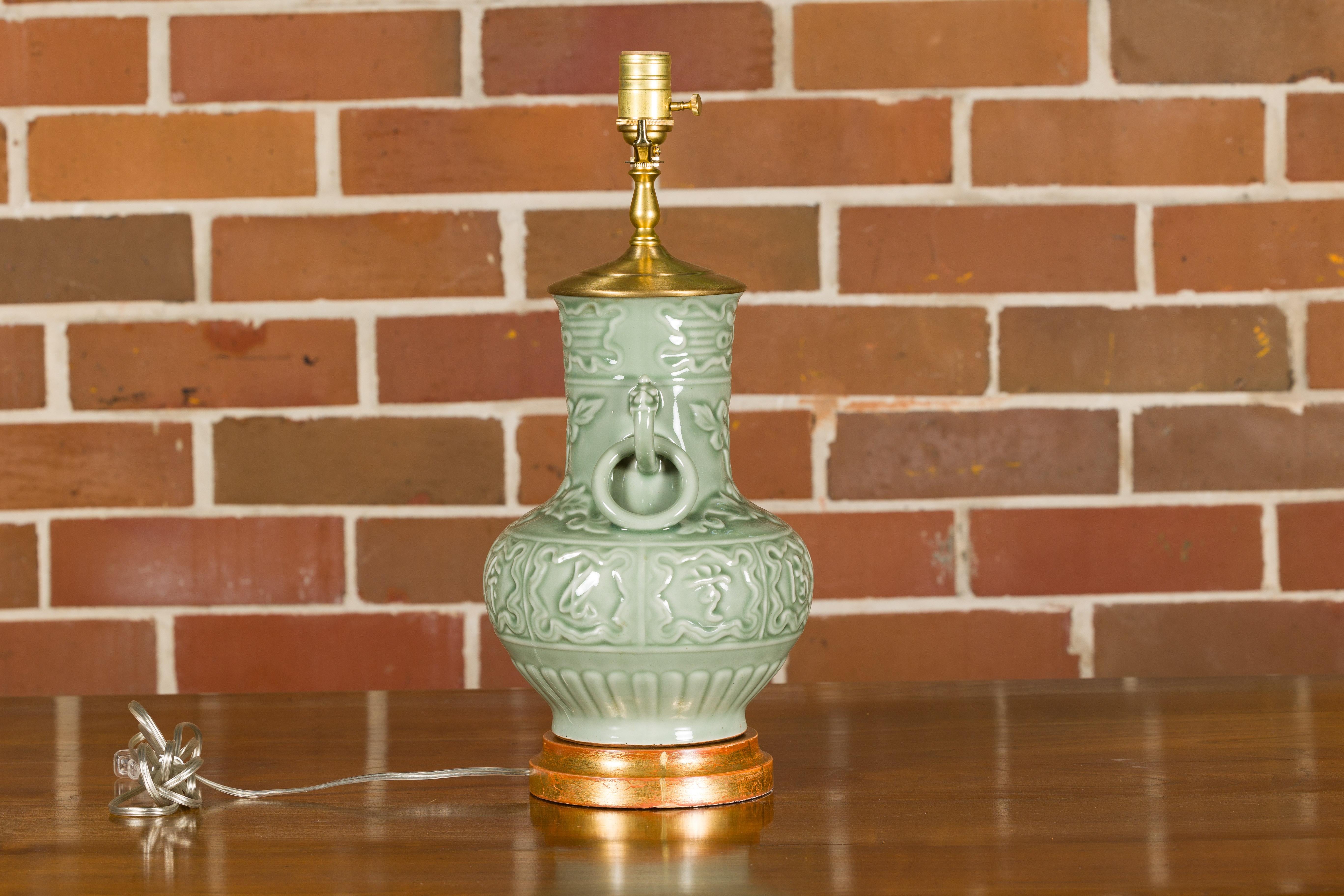 Glazed Celadon Table Lamp with Raised Motifs on Circular Gilt Base, Wired for the USA For Sale
