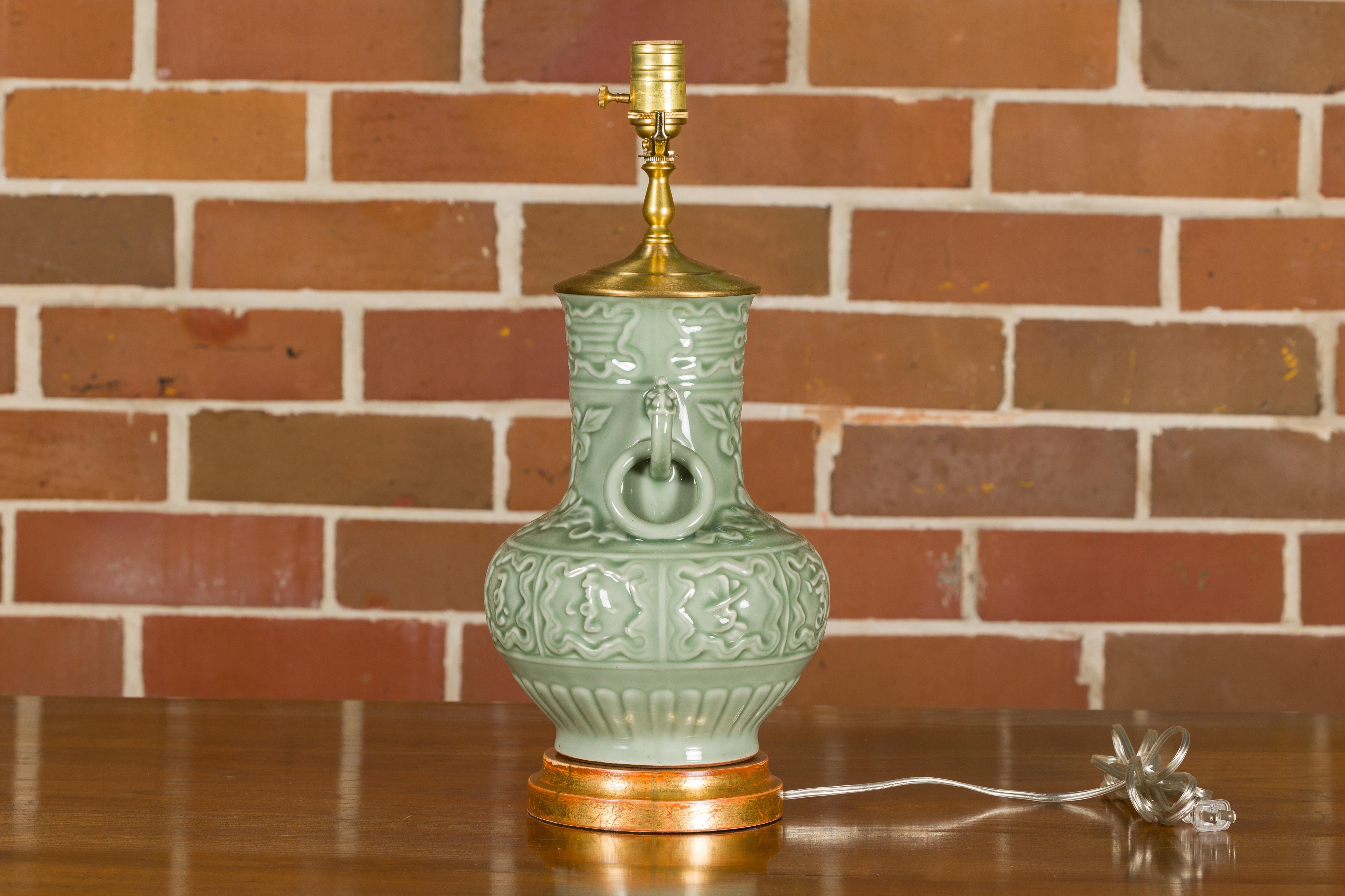 Celadon-Tischlampe mit erhabenen Motiven auf rundem vergoldetem Sockel, verdrahtet für die USA (Keramik) im Angebot