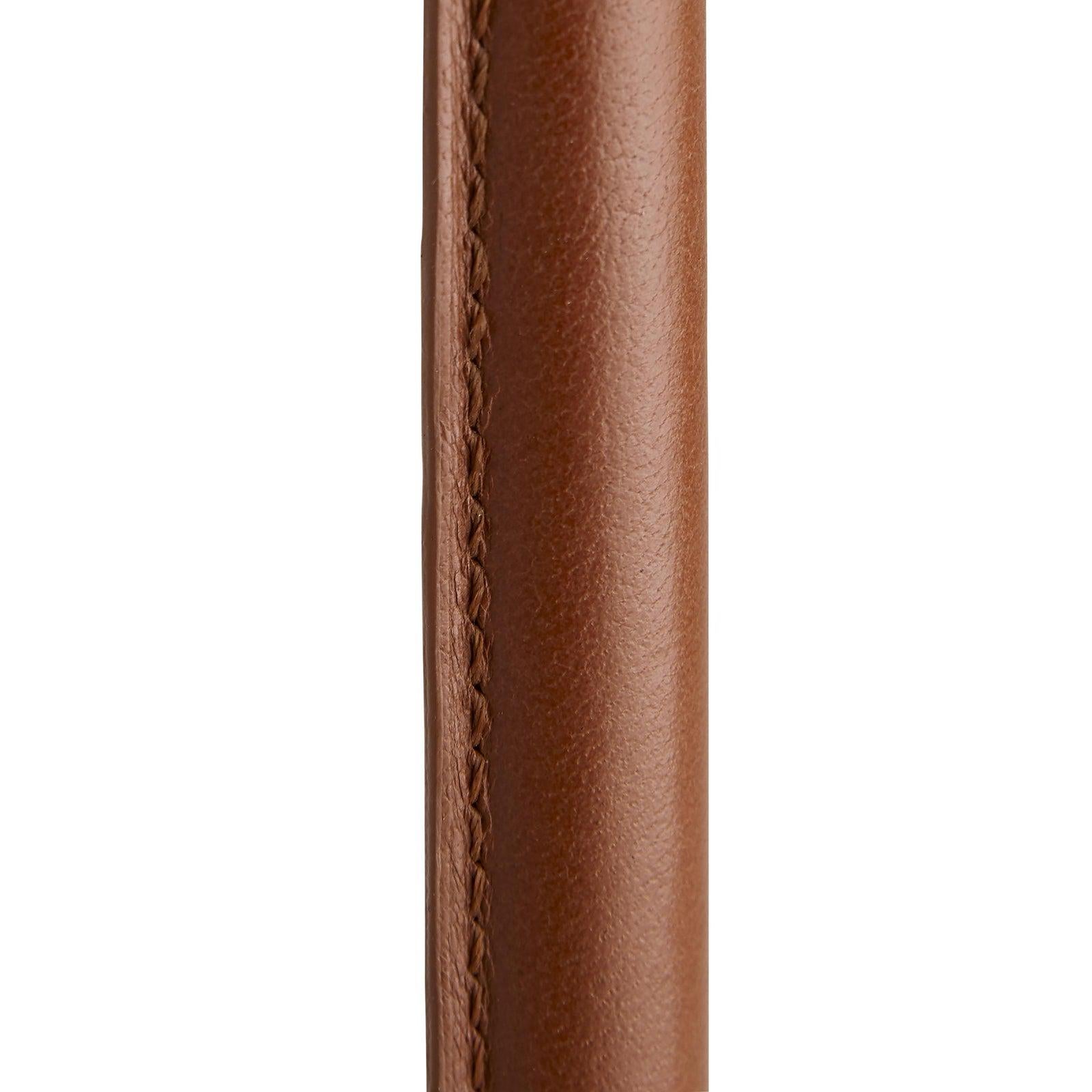 Bi-tonal finished brass forms the structure; the top has a brushed finish while the adjustable stem and accents have an antiqued golden hue. Taking acue from fashion houses, Celerie designed the cognac leather wraps to feature exposed stitching,