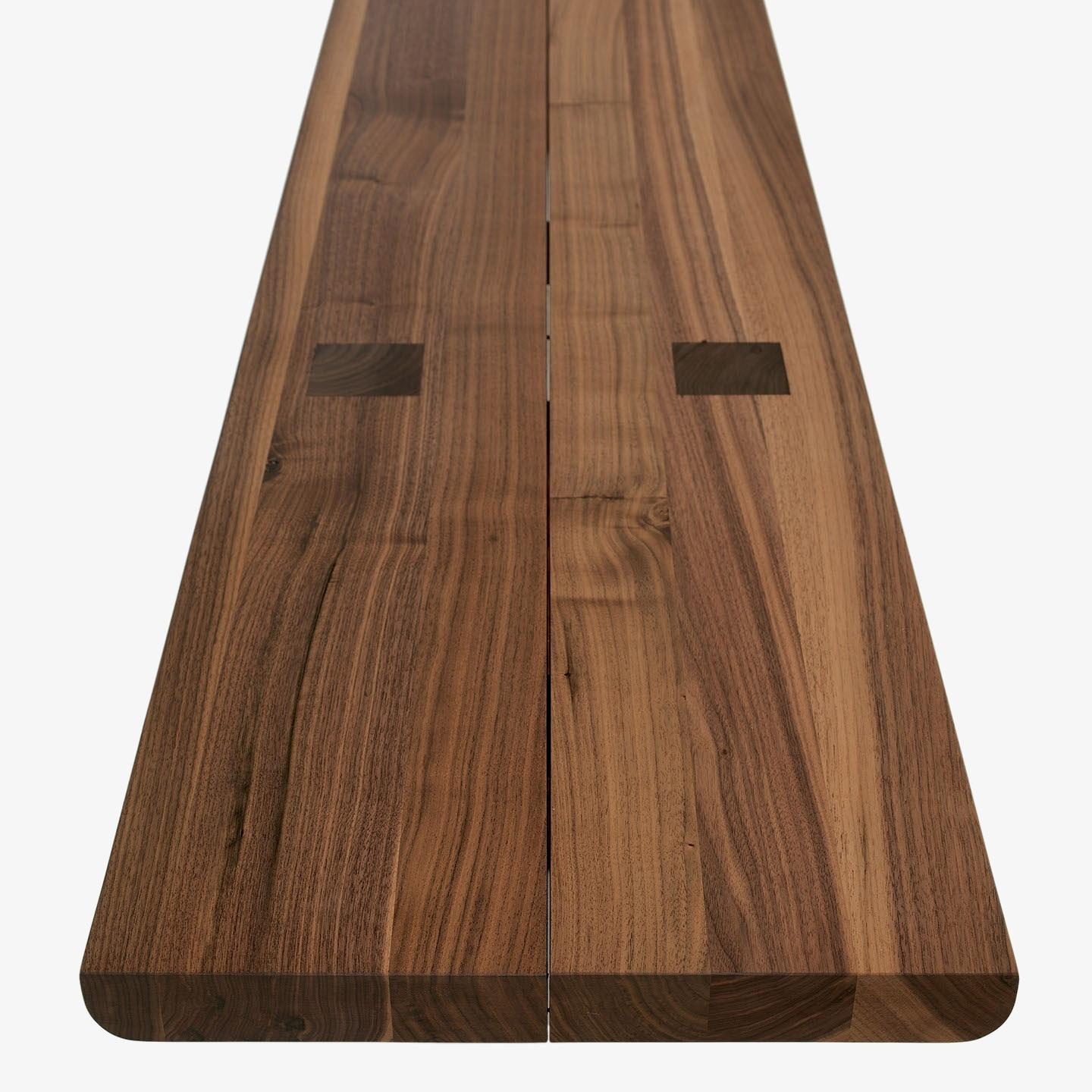 This bench is a study in clean, minimalist design, showcasing the natural beauty of solid wood.  Constructed entirely from glued lists of solid wood, it offers both strength and a visually appealing grain pattern. A distinctive central gap runs