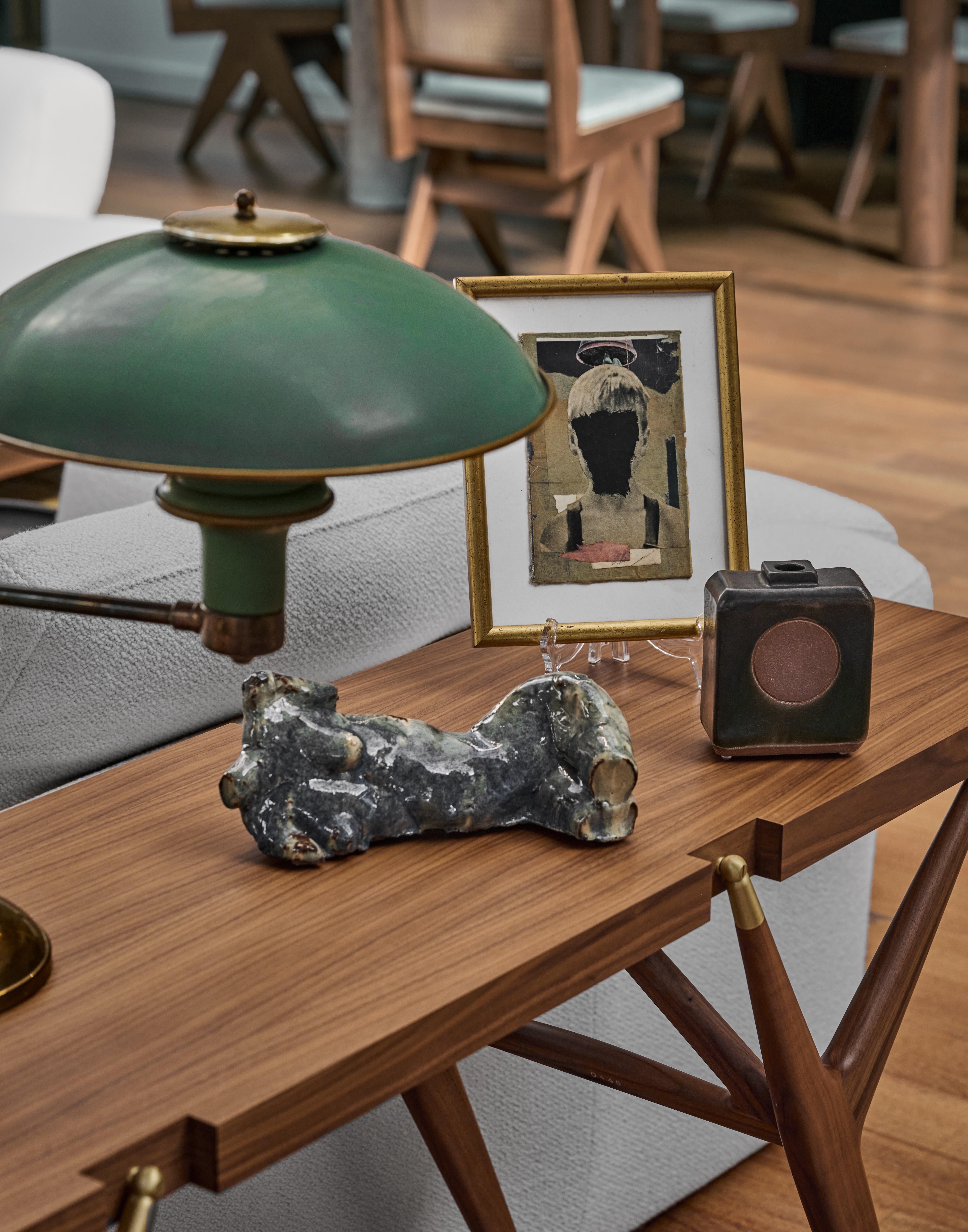 This evocative ceramic sculpture captures the human form in a moment of serene repose. Its brilliant marbled finish, oscillating between deep blues and silvered grays, suggests both geological formation and celestial movement. The reclining figure,