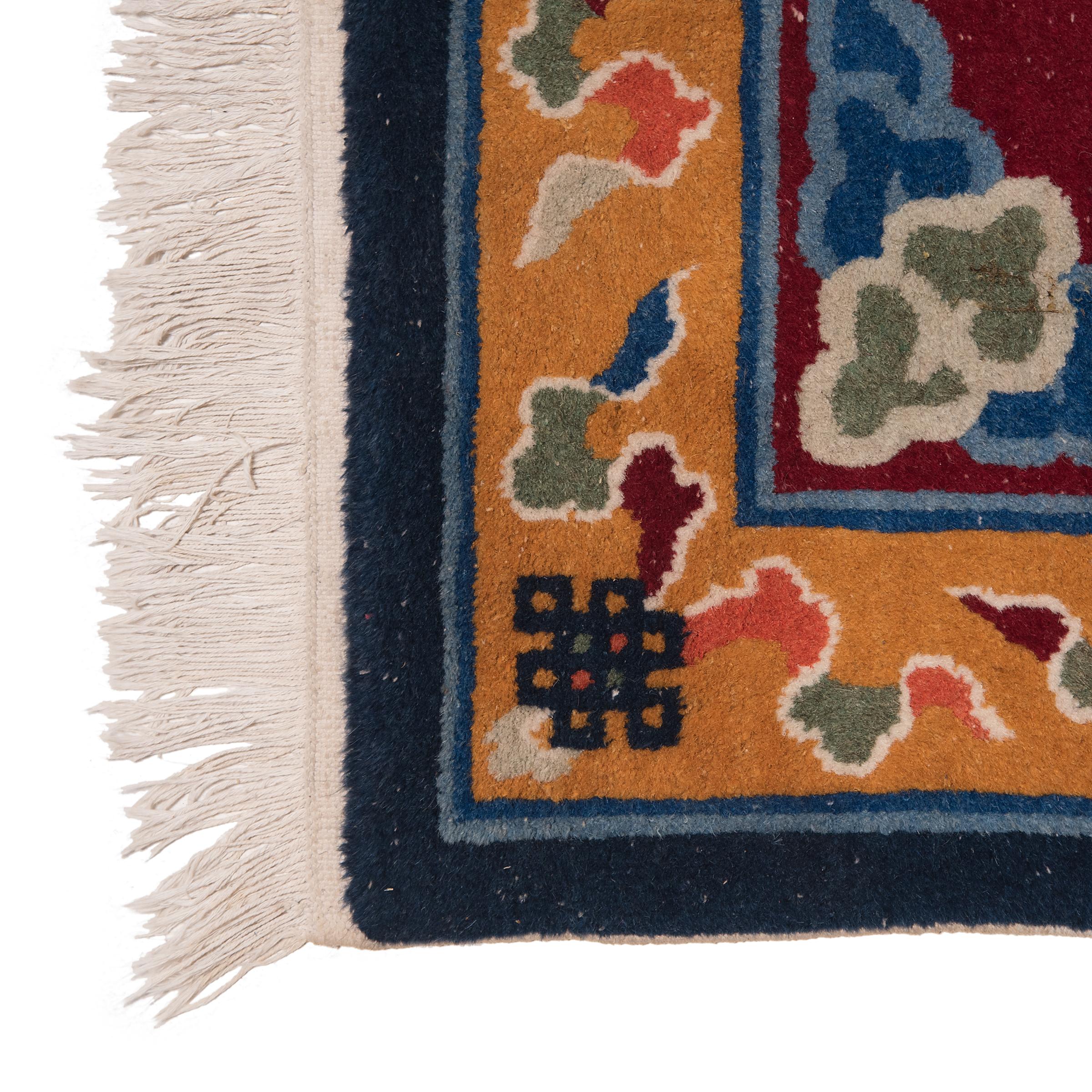 This small rectangular area carpet recreates traditional Chinese carpet designs with a bold color palette of maroon, navy and mustard yellow. Set against the wine-red field is a central medallion of a celestial dragon flying towards a flaming pearl,