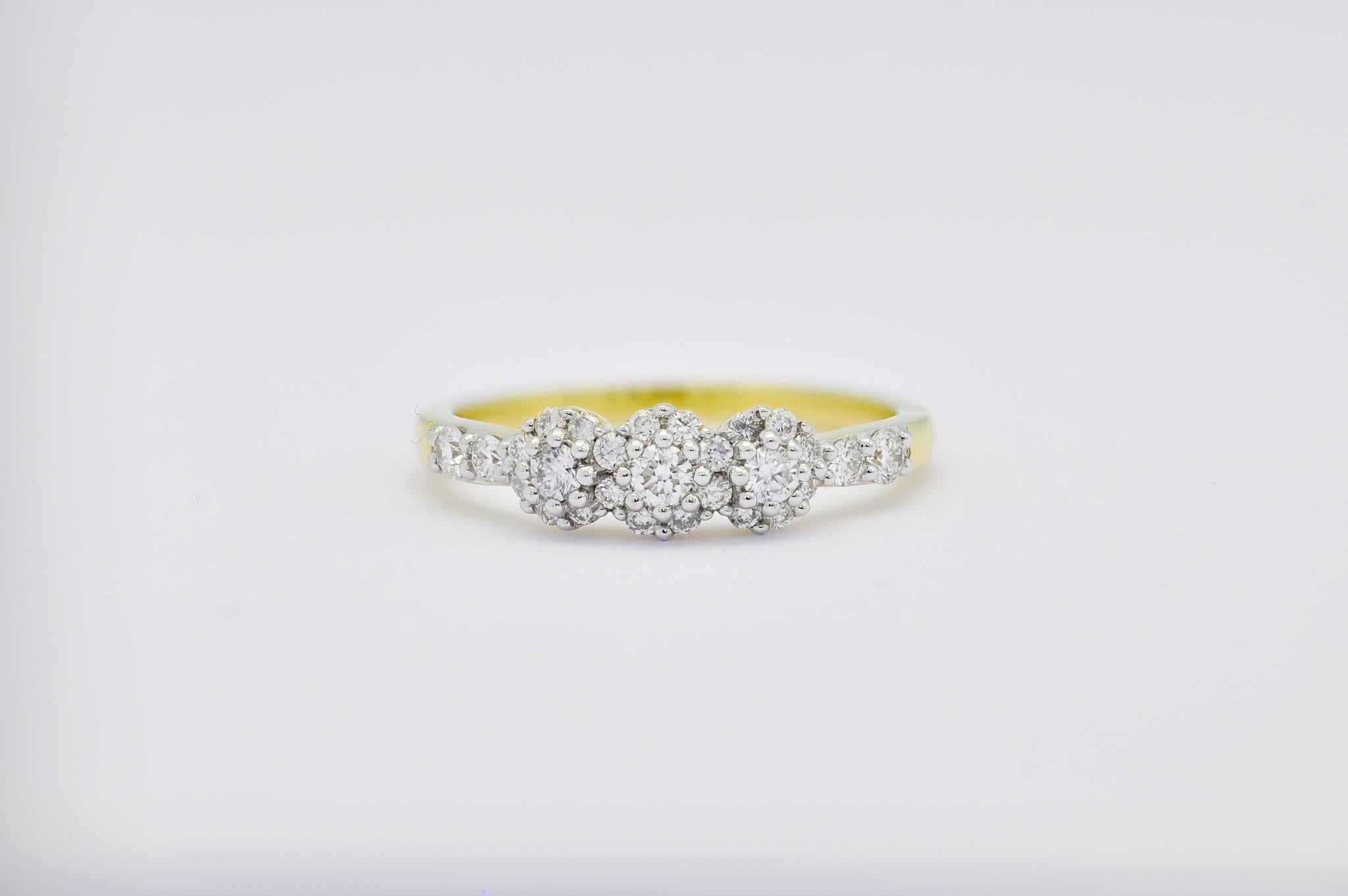 Lassen Sie sich von der himmlischen Schönheit unseres Trilogie-Cluster-Rings verzaubern, einem atemberaubenden Meisterwerk mit natürlichen Diamanten, die in feinstes 18-karätiges Gelbgold gefasst sind. Dieser bezaubernde Ring besteht aus einem Trio