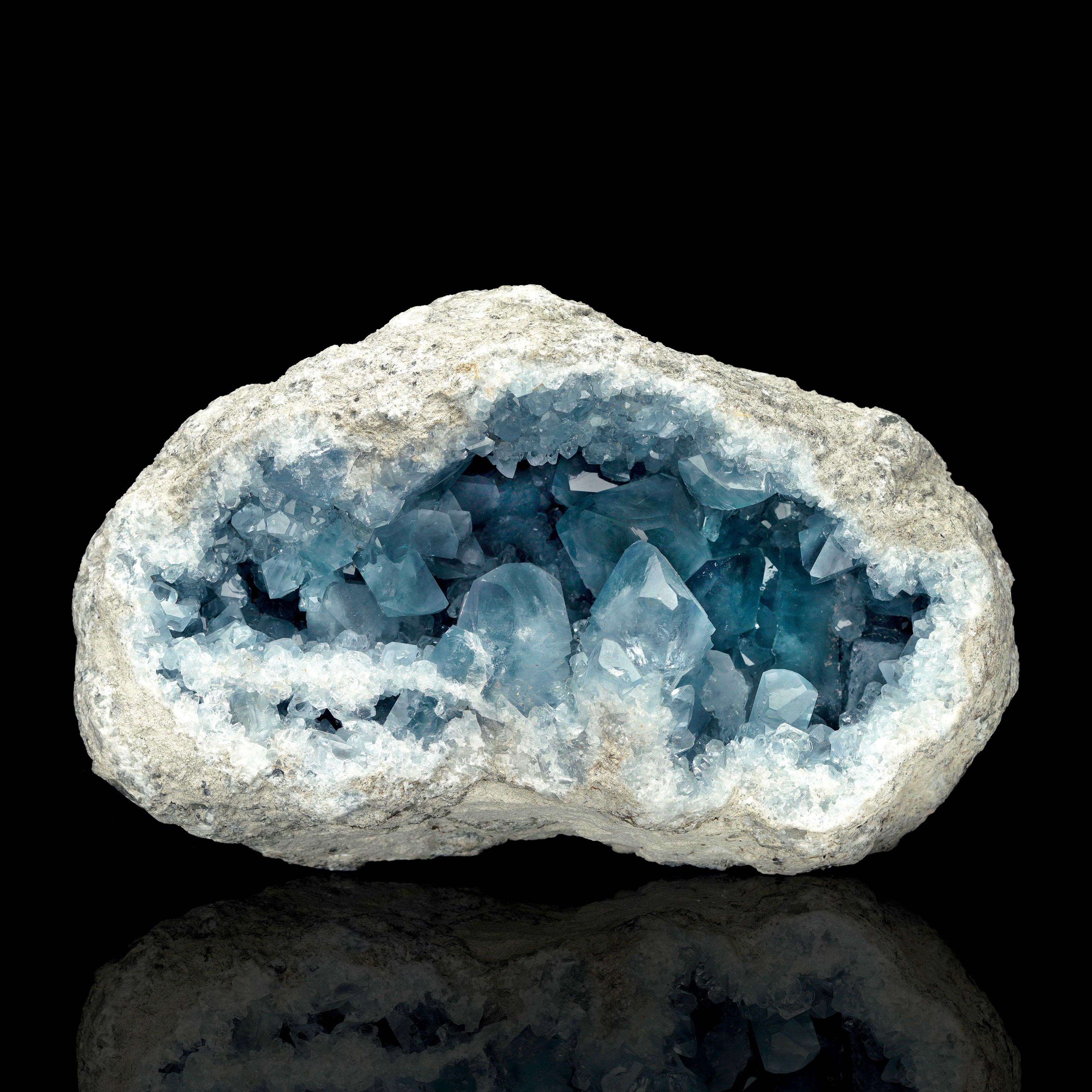 Questo splendido geode di celestite proveniente dal Madagascar è un capolavoro naturale, caratterizzato da un vibrante gruppo di cristalli blu cielo incastonati in una robusta pietra naturale. I cristalli di vetro ben formati riflettono