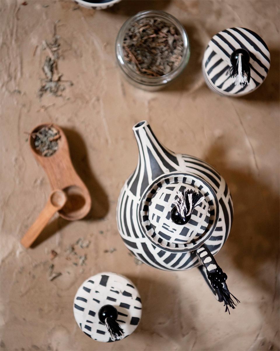 Une théière artisanale pour votre rituel matinal
La théière Celia en céramique faite à la main présente un style rustique magnifique, avec des perles fantaisistes et des détails en tissu. Cette pièce unique est parfaite pour les thés de l'après-midi