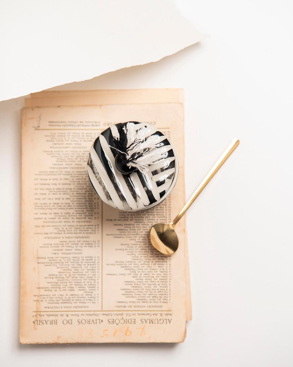 A handmade sugar pot to store your sweetener
This sweet sugarpot will add a whimsical splash of rustic charm to your home decor! Lovingly handmade in ceramic and adorned with beaded cotton thread details, this black & white striped sugarpot with lid