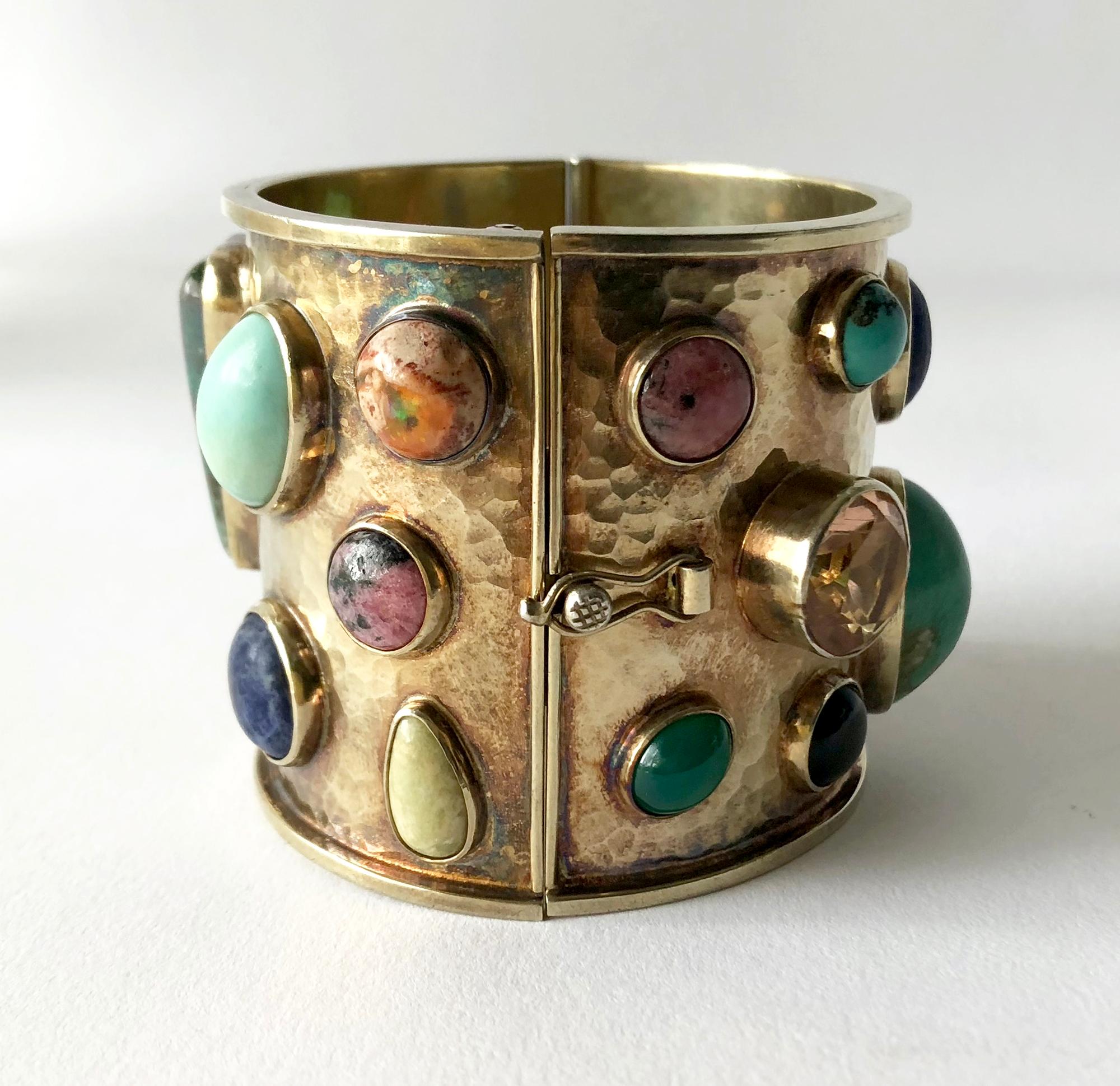 Multi colored semi-precious gemstones set in a sterling silver hinged cuff, created by Celia Harms of Mexico.  Each stone is bezel set within a hand hammered silver, gold washed bracelet.  Bracelet has a wearable wrist length of 6.75