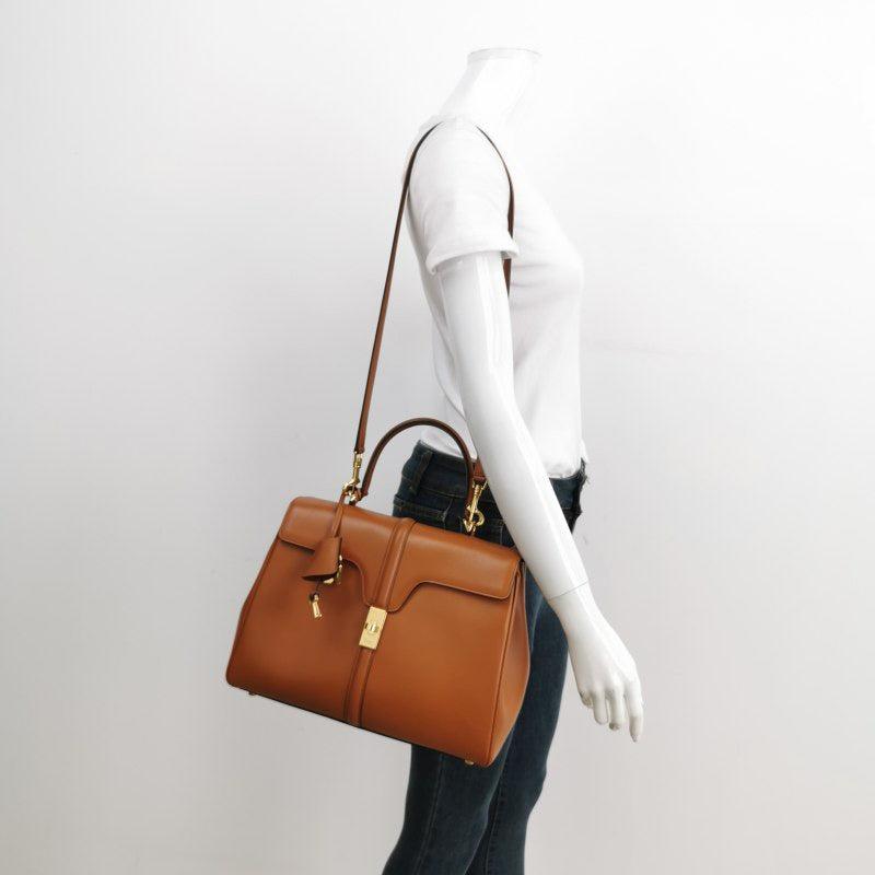 Celine 16 Bag Medium Caramel Natural Tan Smooth Calfskin Leather

  This Celine 16 Bag is elegantly designed, showcasing a unique blend of classic and modern elements. Dressed in a stunning natural tan color, it boasts a front clasp, top handle, and