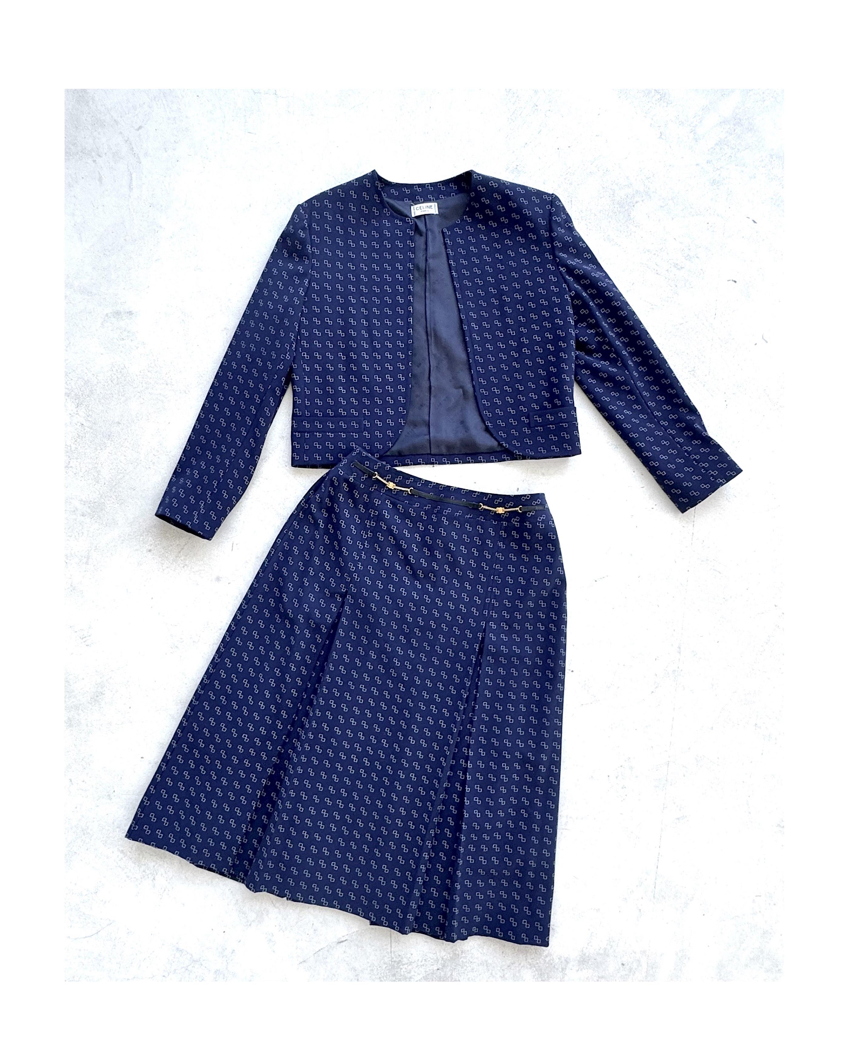 Step into timeless Parisian elegance with this Céline vintage 1970s wool skirt suit, a stunning two-piece set featuring a tailored long-sleeve cropped blazer and a high-waisted A-line midi skirt. Crafted in luxurious navy blue wool with a delicate