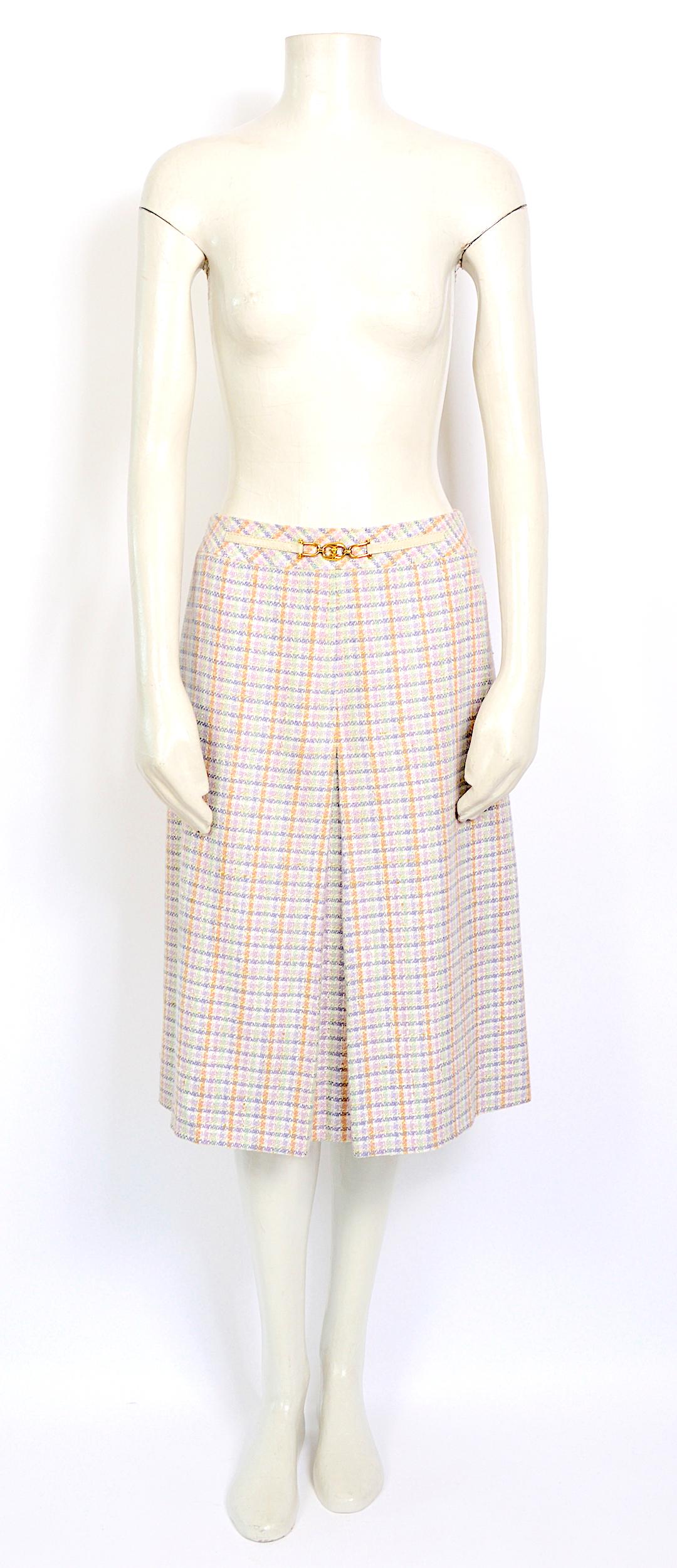The only one front and back pleat A-Line style make this skirt a touch more flattering. 
Celine ivory wool pleated skirt featuring pastel lilac, green and pink check pattern, a center back zip, a front leather and gold-tone Celine signature buckle,
