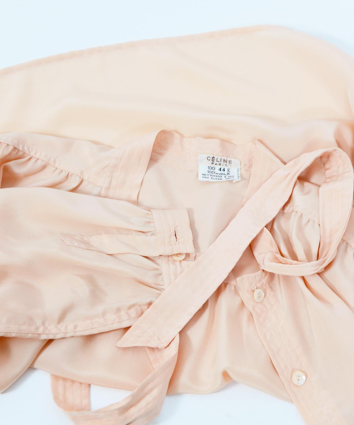 Exquisite CELINE nude or peach color silk blouse.  Signed buttons + logo on the front of the shirt. French Size 44 100% silk Measurements are taken flat Sh to Sh 16,5inch/42cm - Ua to UA 20inch/51cm(x2) - Total Length 26inch/56cm - Sleeve 24inch/61cm