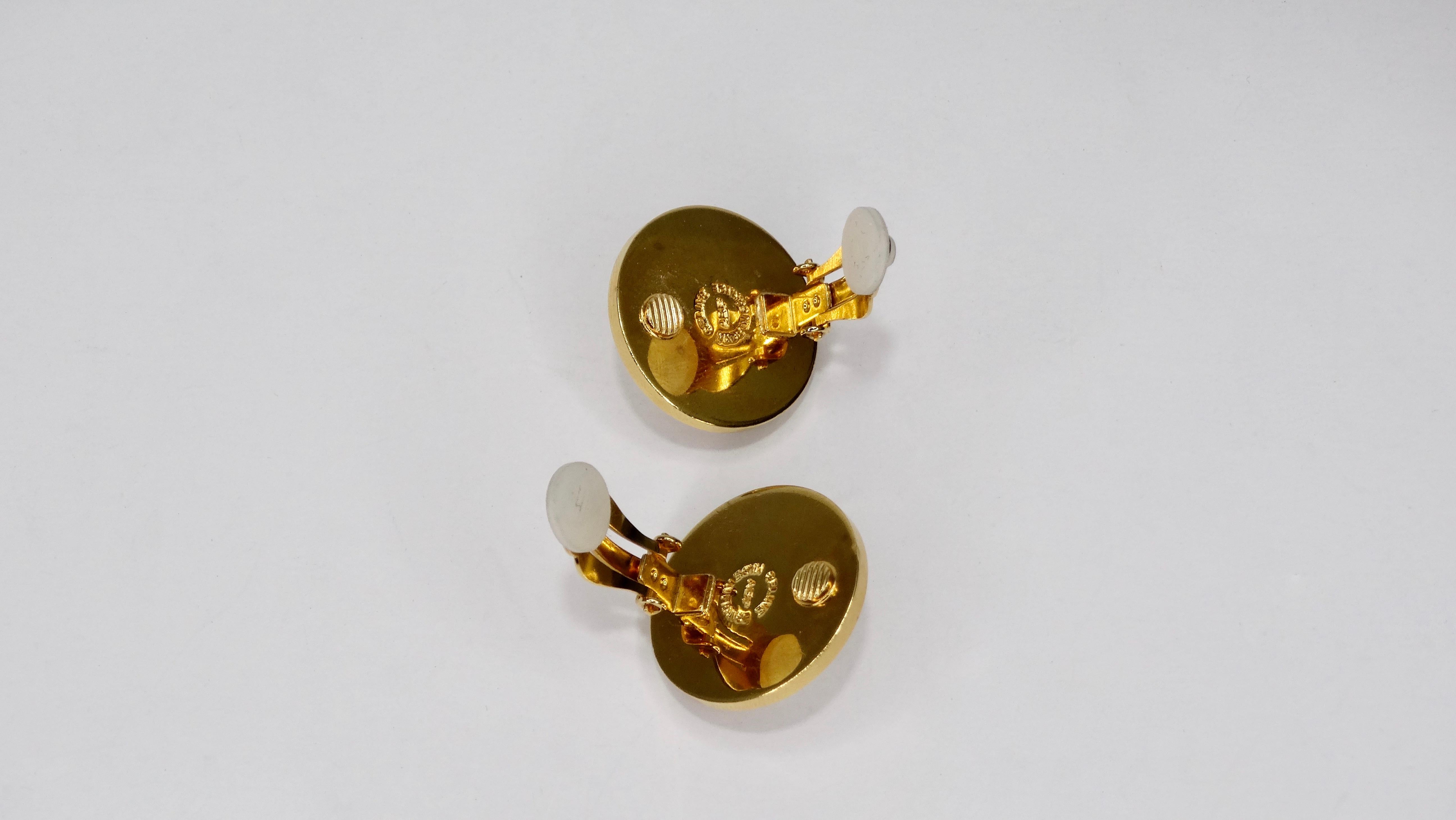 Perfect Celine earrings to add to your collection! Circa 1980s, these gold plated circular earrings are embossed with Celine Paris and feature a faux pearl in the middle. Clip on closures and original box included. Perfect to pair with your favorite