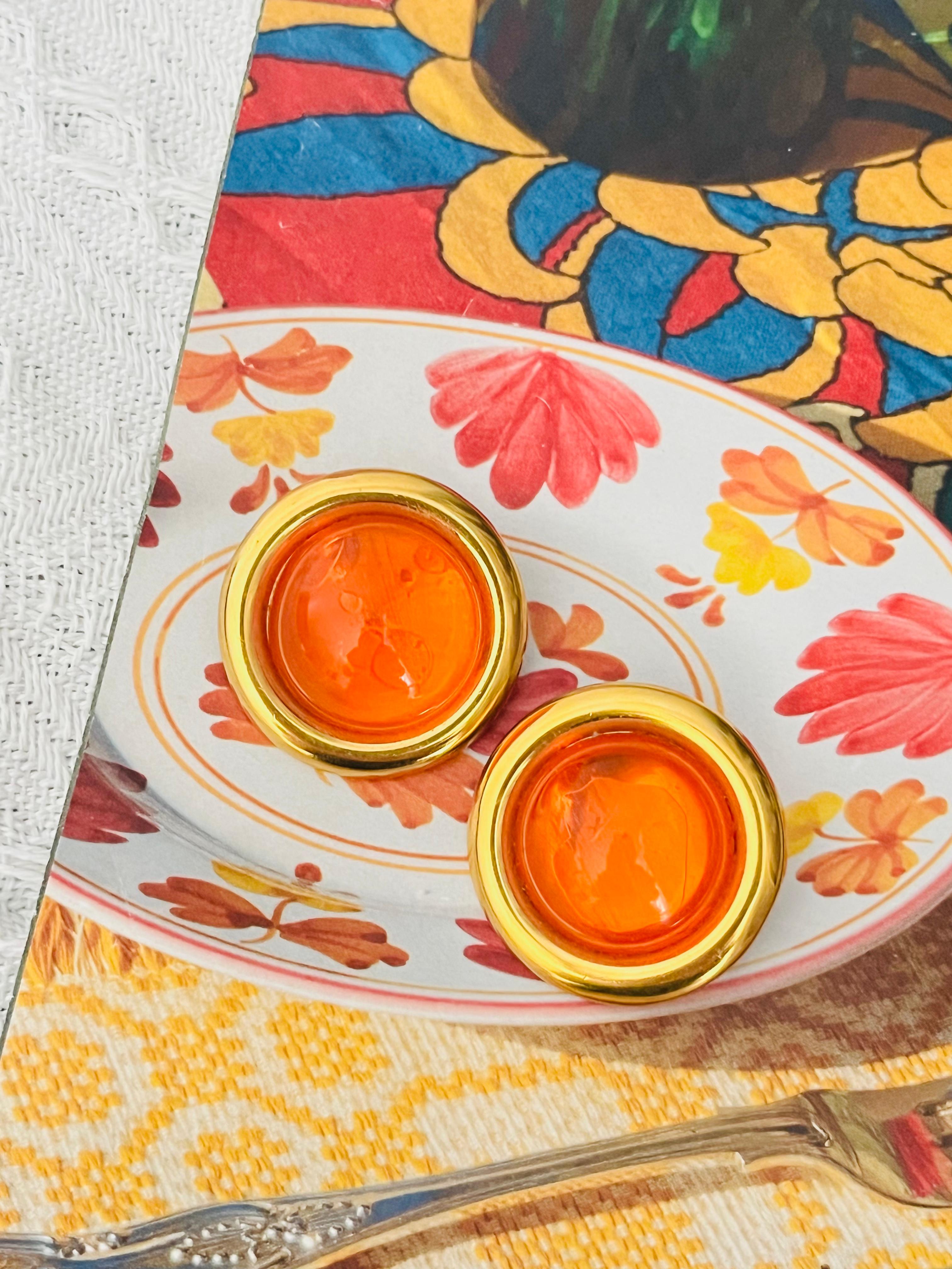 Celine 1992 Vintage Large Citrine Orange Cabochon Jelly Belly Circle Round Dome Elegant Clip Earrings, Gold Plated

Very good condition. Maybe light scratches or colour loss,  barely noticeable. Bubbles in orange stone, which are come from