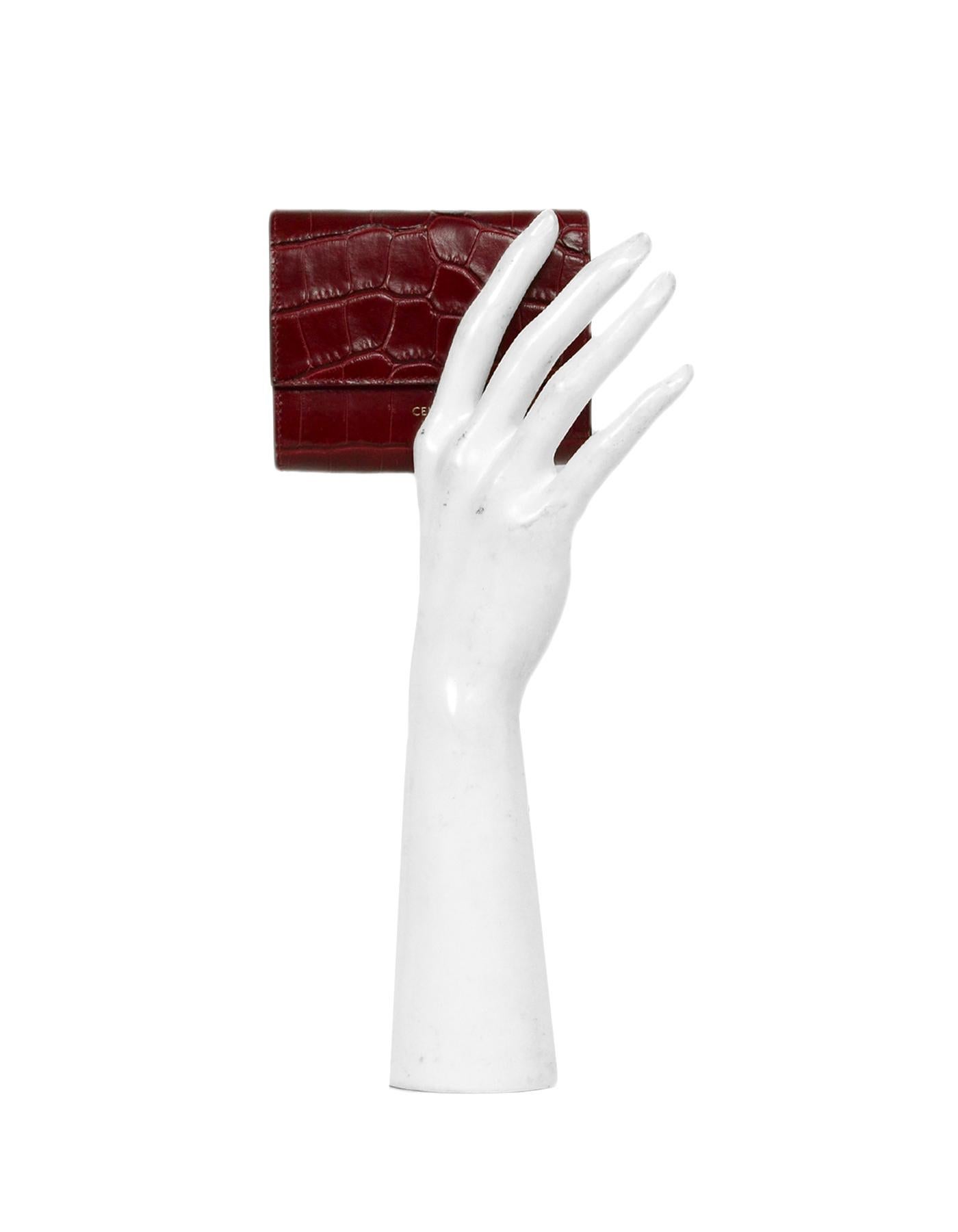 Celine 2019 Burgundy Embossed Croc Trifold Compact Wallet 

Made in: Italy
Year of Production: 2019
Color: Burgundy
Hardware: Goldtone
Materials: Crocodile Leather
Lining: Leather
Closure/Opening: Flap with snap closure
Exterior Pockets: