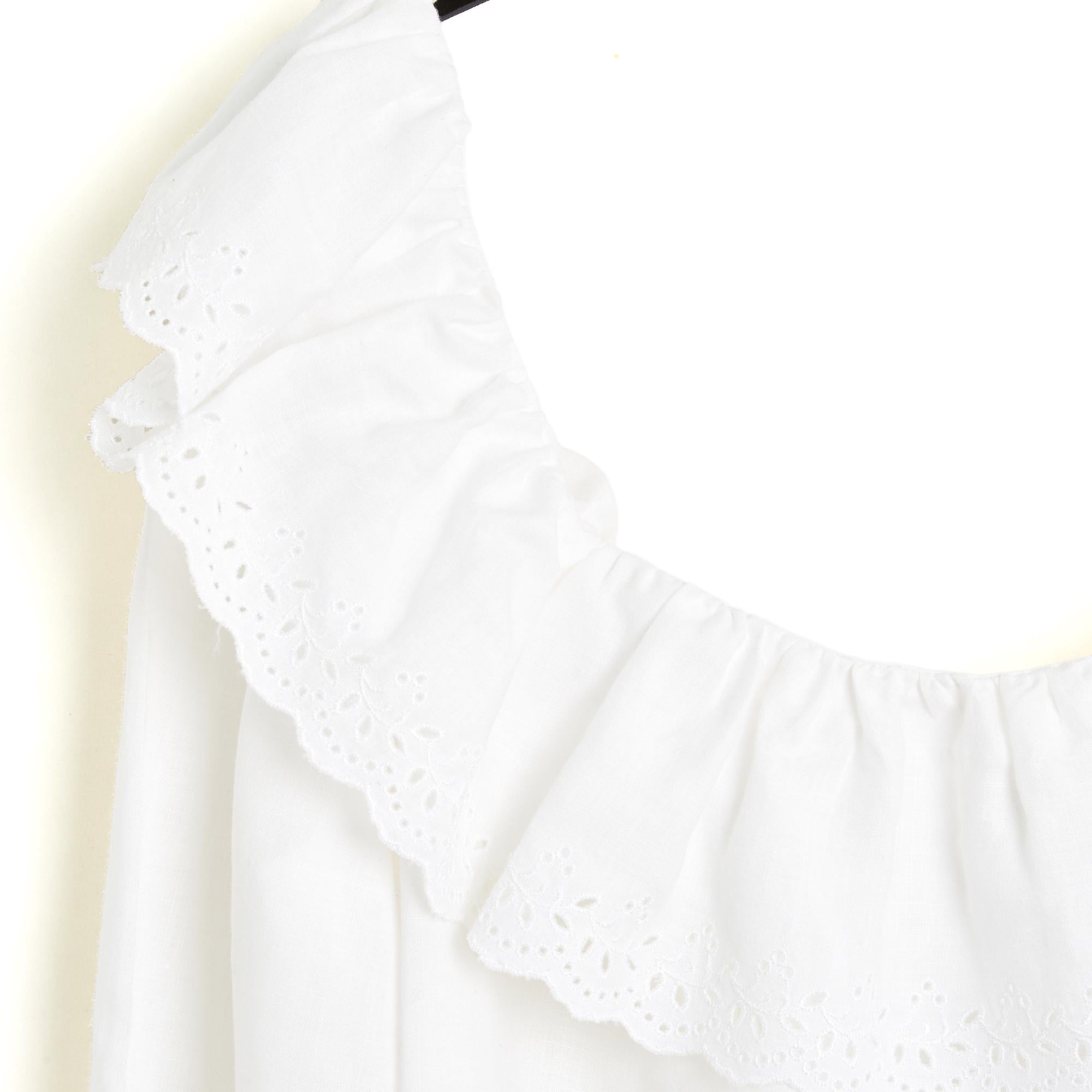Celine top from the SS2020 collection by Hedi Slimane in white linen, wide boat neck with ruffle trimmed with English lace, flared cut, long sleeves with wide ruffle, tightened by an elastic, button closure in the back. Size 40FR or US12 and US10: