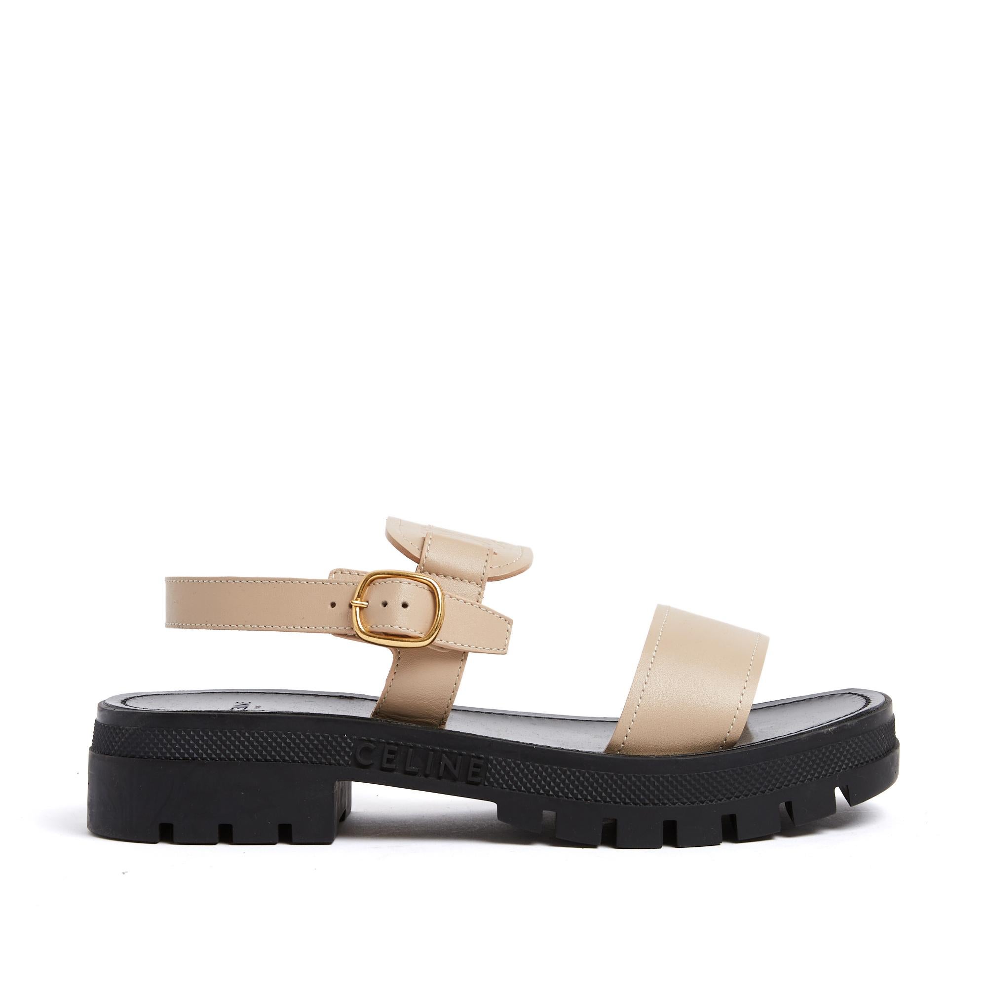 Sandales Celine série Triomphe Cléa en cuir lisse beige avec le logo Triomphe sur la bride supérieure, fermeture par boucle à ardillon en métal doré, semelle intérieure en cuir, semelle extérieure crantée en caoutchouc noir avec le logo Celune.
