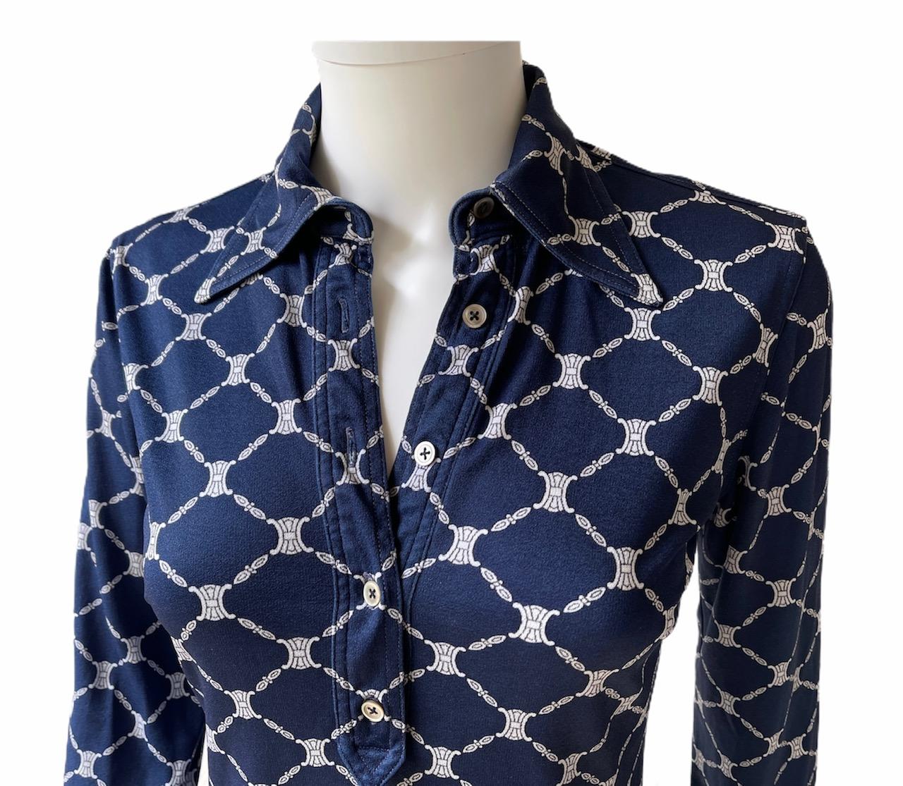 CELINE, Made in Italy, circa 70's.
Blue crepe de chine long sleeves shirt with a classical collar. The famous Triomphe logo is printed in all-over. 
There is no size tag but it fits Extra Small. Please see measurements bellow, taken flat and