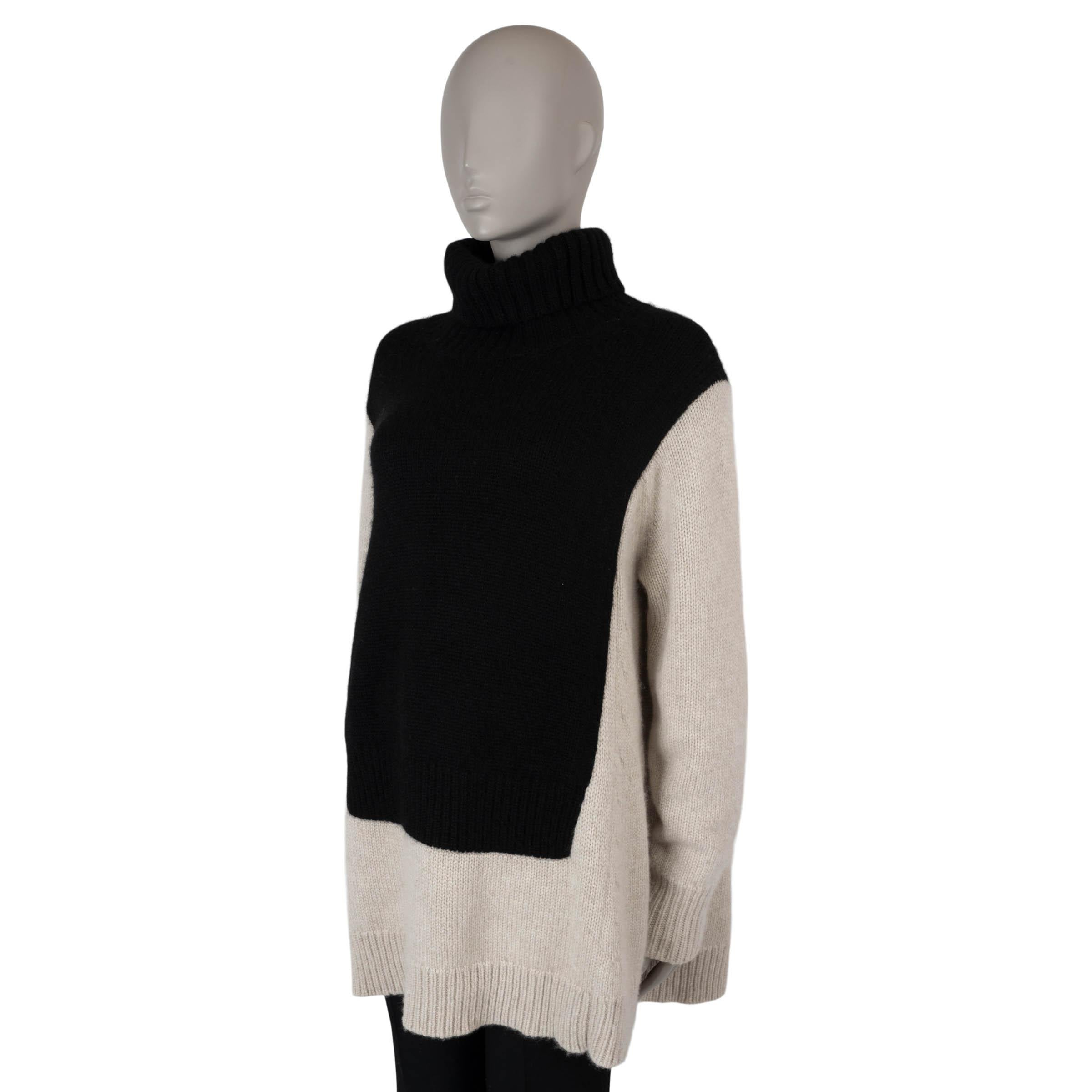 This 100% authentic Céline by Phoebe Philo bicolor sweater is crafted from luxurious beige and black colorblock cashmere (100%). It features an oversized A-line silhouette with dropped shoulders, a relaxed rib-knit turtleneck, and slightly longer