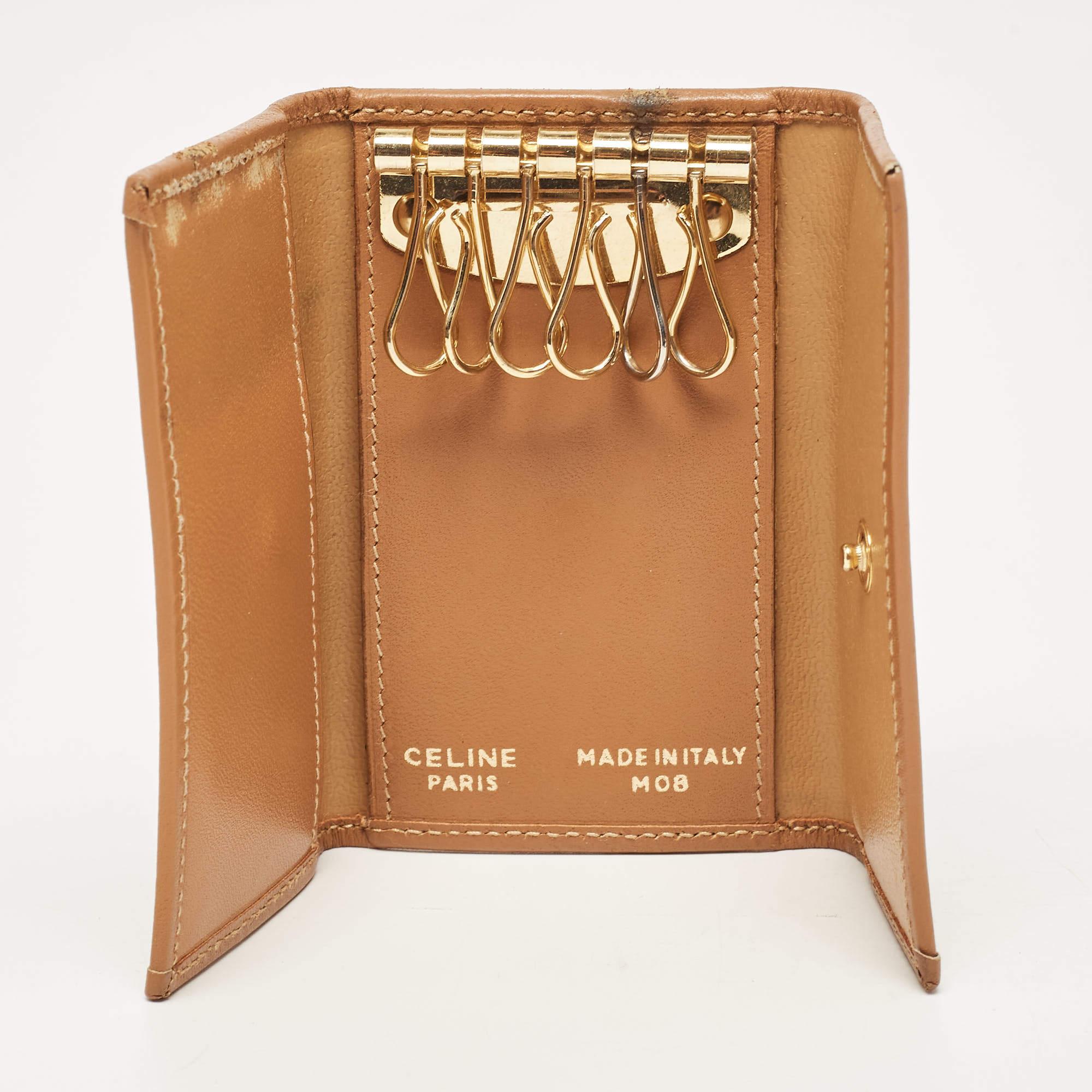 This designer key ring case is made from coated canvas along with leather and we cant help but admire its fine finish and simple design. It features a notable logo.