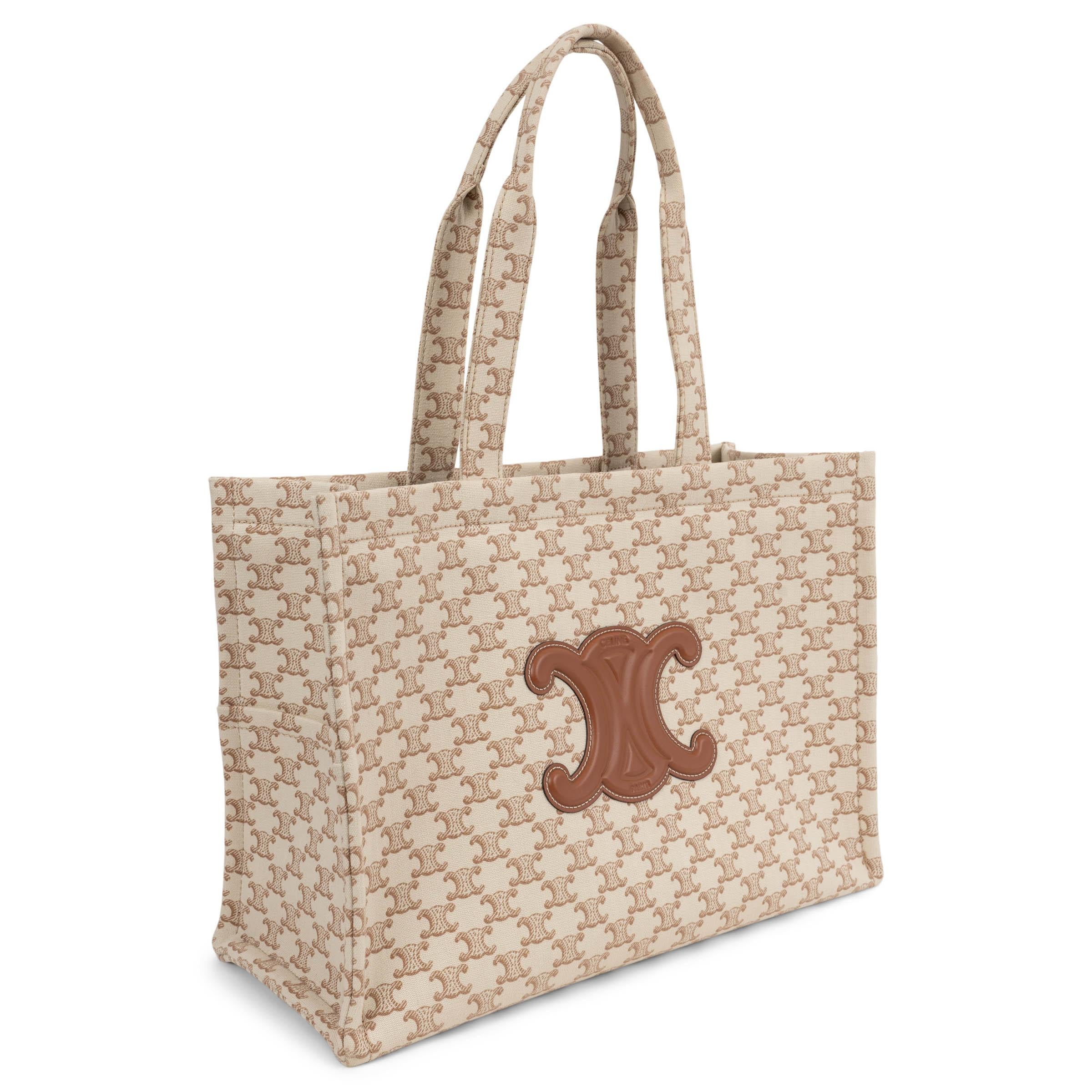 Dieser 100% authentische Celine Large Cabas Thais Shopper ist aus cremefarbenem Canvas gefertigt und mit einem braunen Triomphe-Motiv überzogen. Ein cognacbrauner Triomphe-Aufnäher aus Leder akzentuiert die Vorderseite und ist ein typisches Detail.