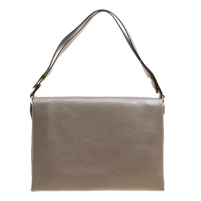 Simple and minimalist, this grey leather Celine handbag is a perfect everyday bag. The suede interiors have two open and one zippered compartment. The blade flap looks stylish with the gold tone push-lock and the bag is complete with adjustable