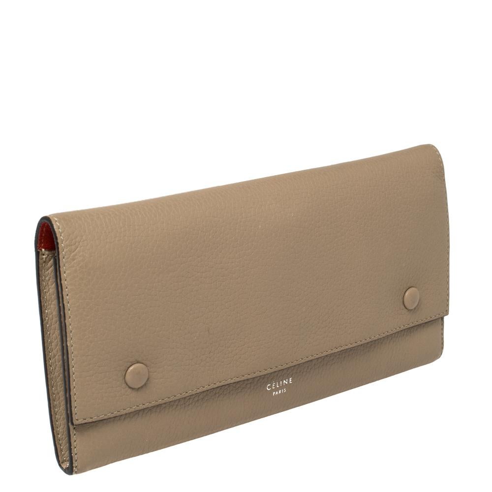 This Celine wallet is built for making a statement. Crafted from leather, it has a beige exterior and a front flap that opens to a leather and fabric interior housing a zip pocket and multiple card slots. It will surely prove to be an amazing buy!

